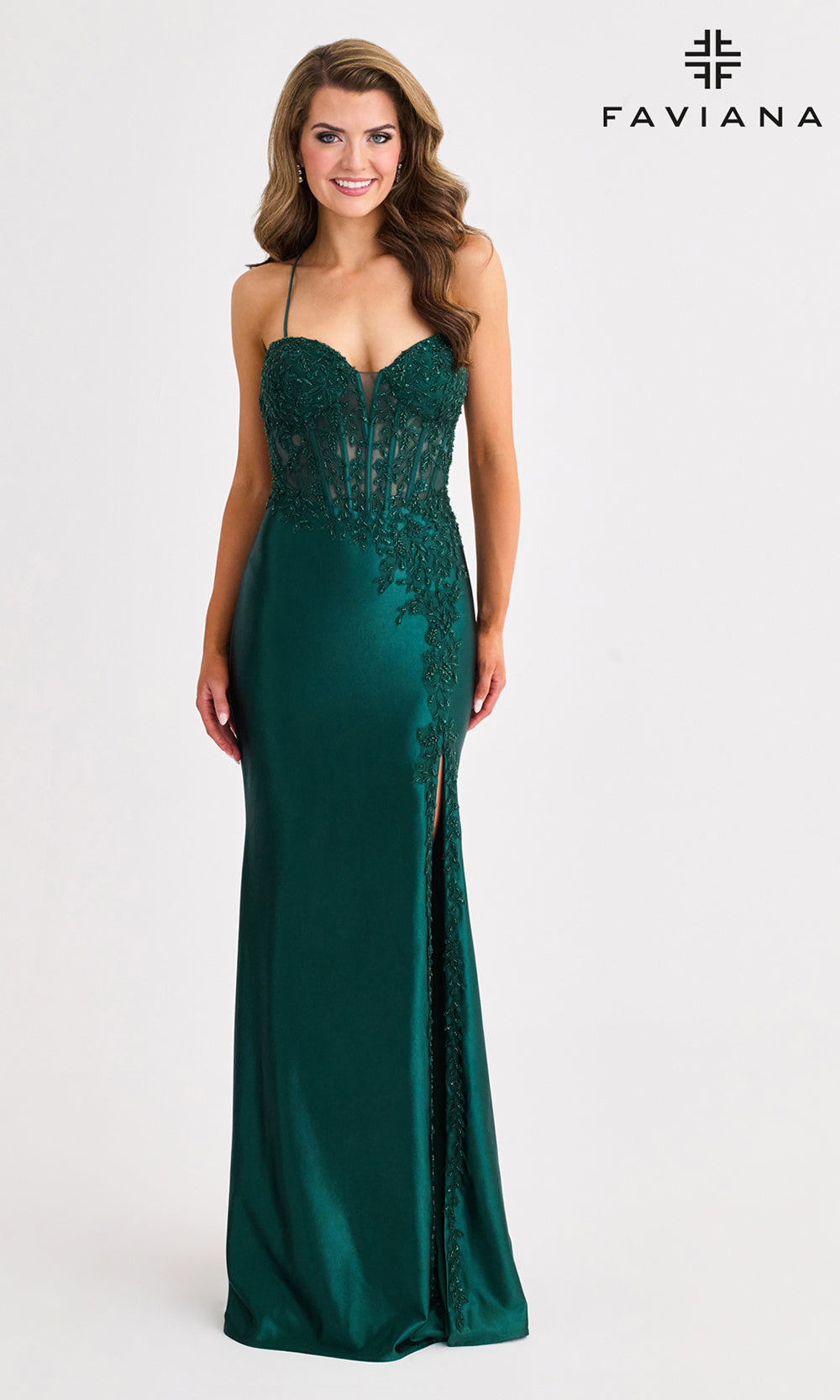 Woman wearing a green evening gown with a slit on a white background, branded 'Faviana'.