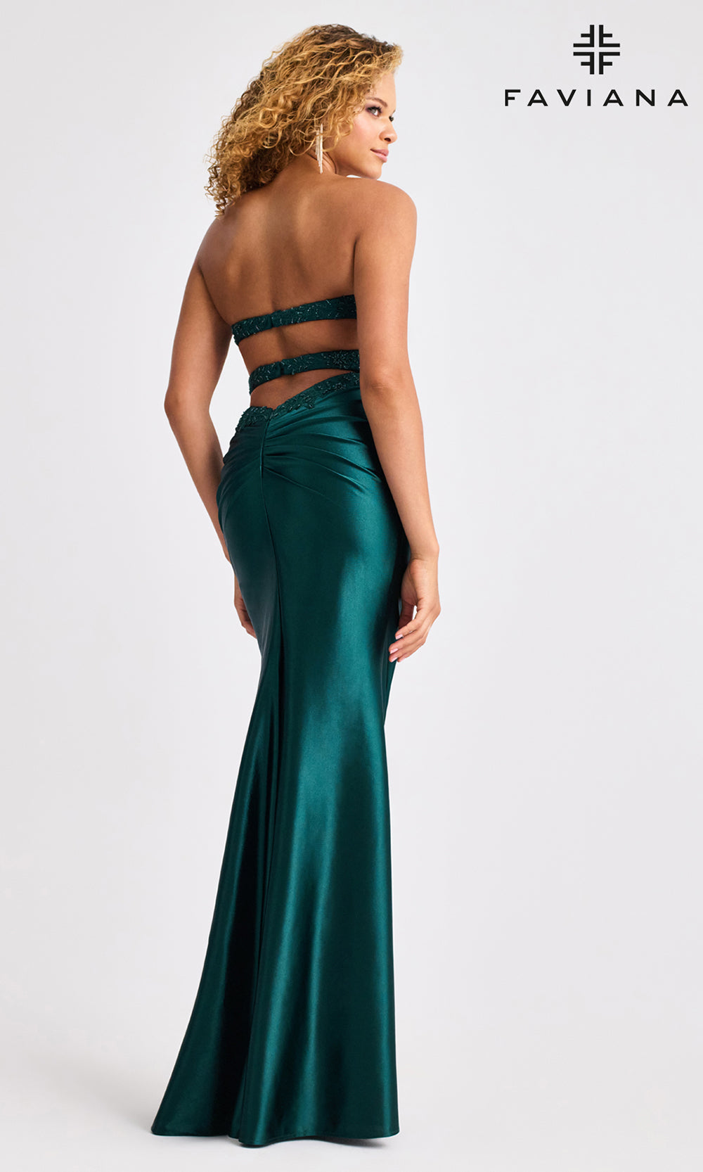 Woman wearing a green evening gown with a visible brand logo on a white background