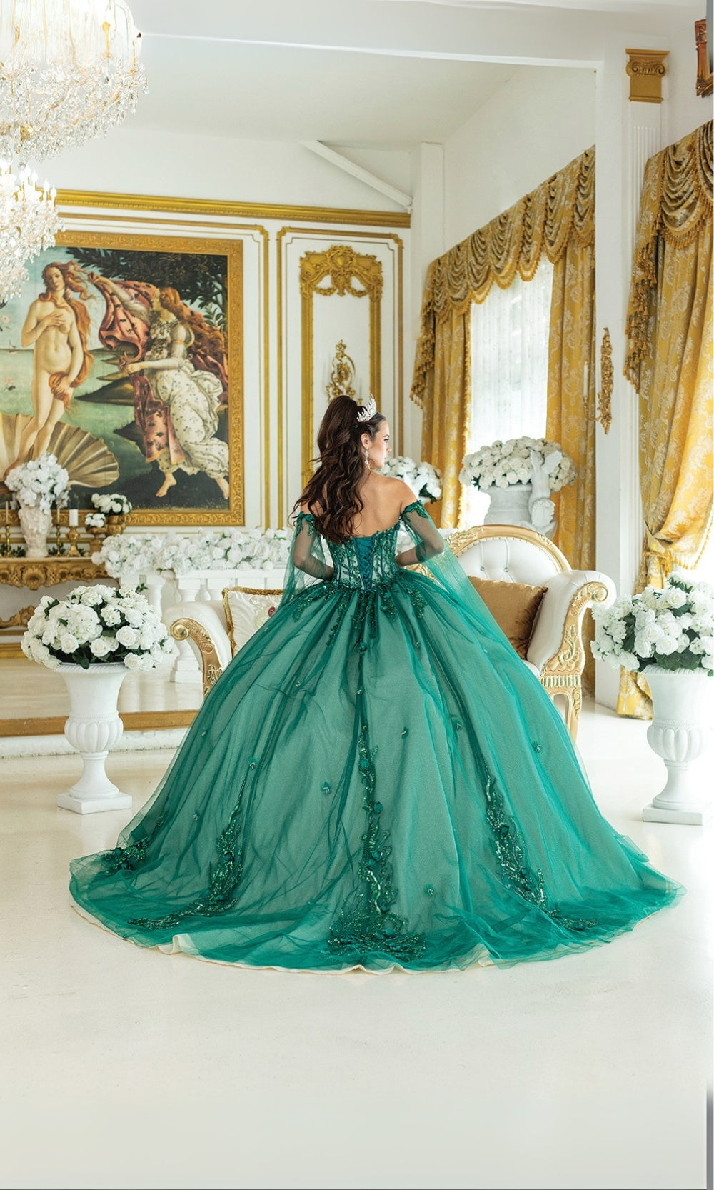 Woman in a green ball gown standing in an opulent room with gold accents and classical art.