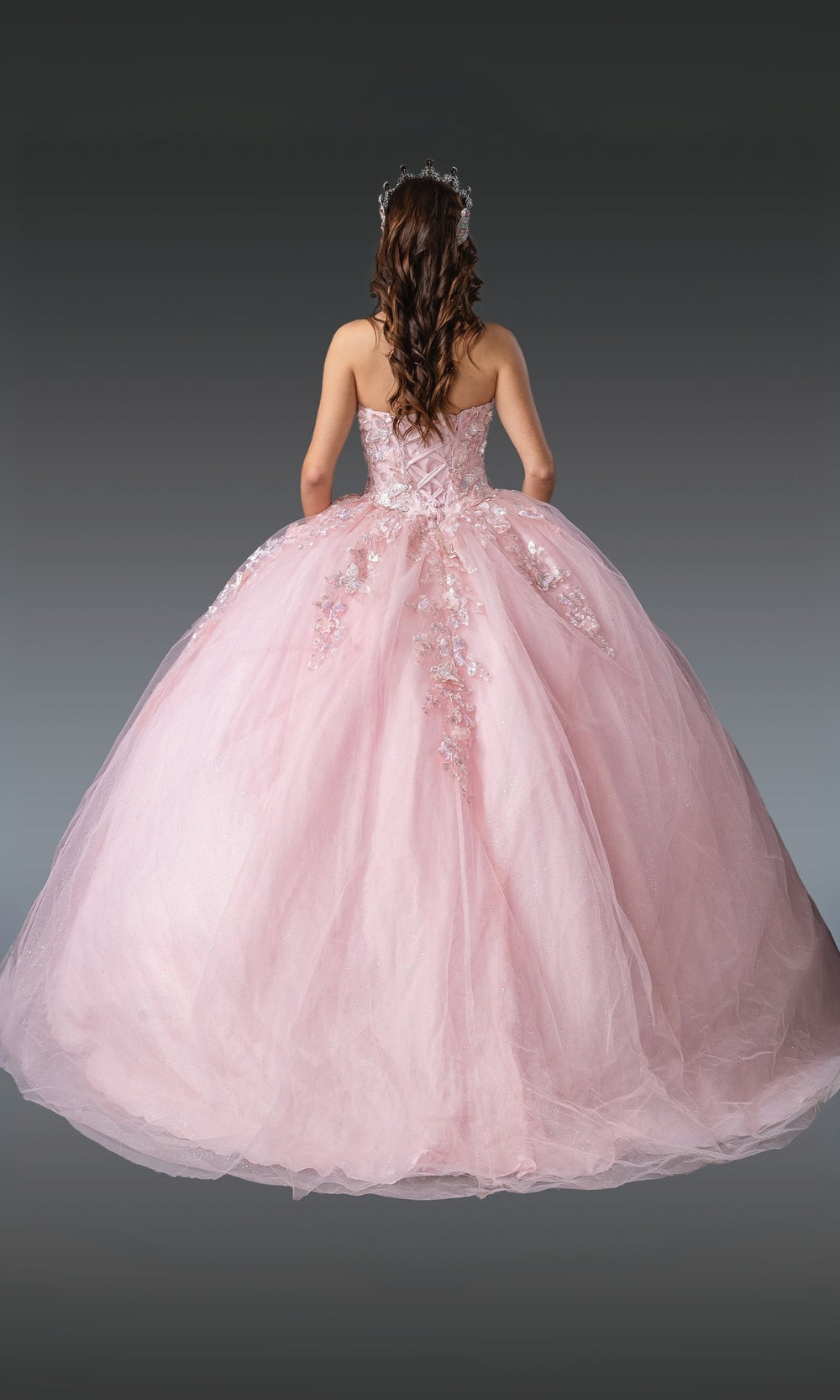 Pink ball gown with floral details on a dark background