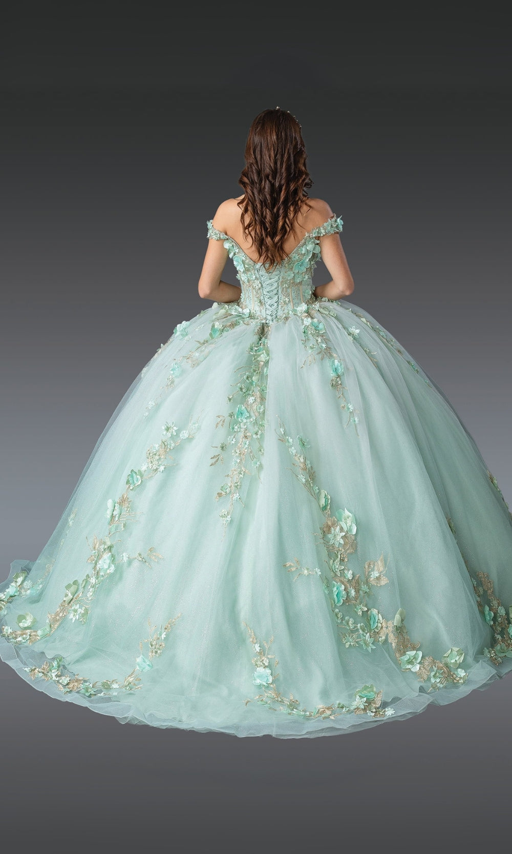Mint green ball gown with floral embellishments on a gray background