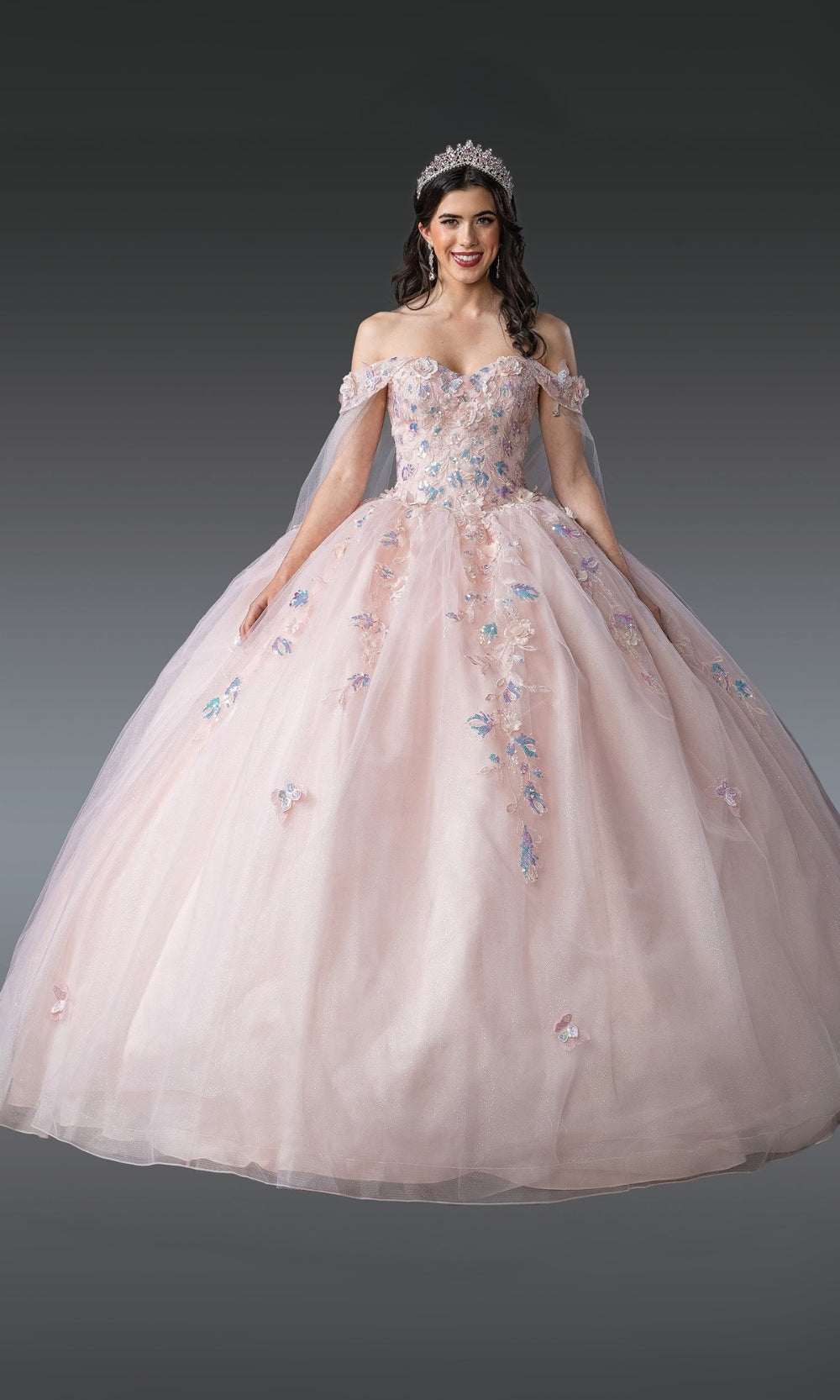 Woman wearing a pink off-shoulder gown with floral embroidery on a dark background