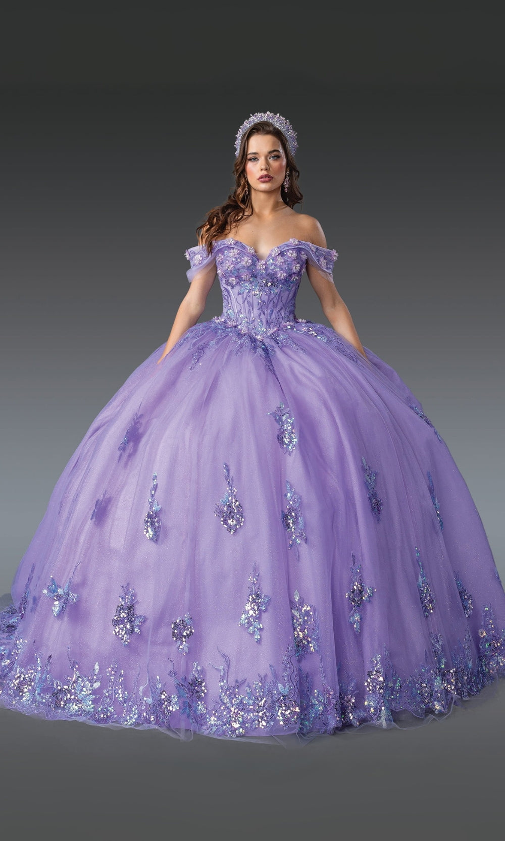 Woman wearing a purple ball gown with floral embellishments on a gray background