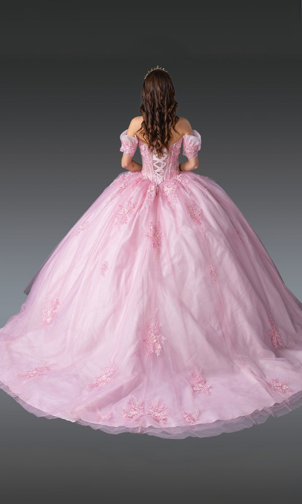 Pink ball gown with floral details on a gray background