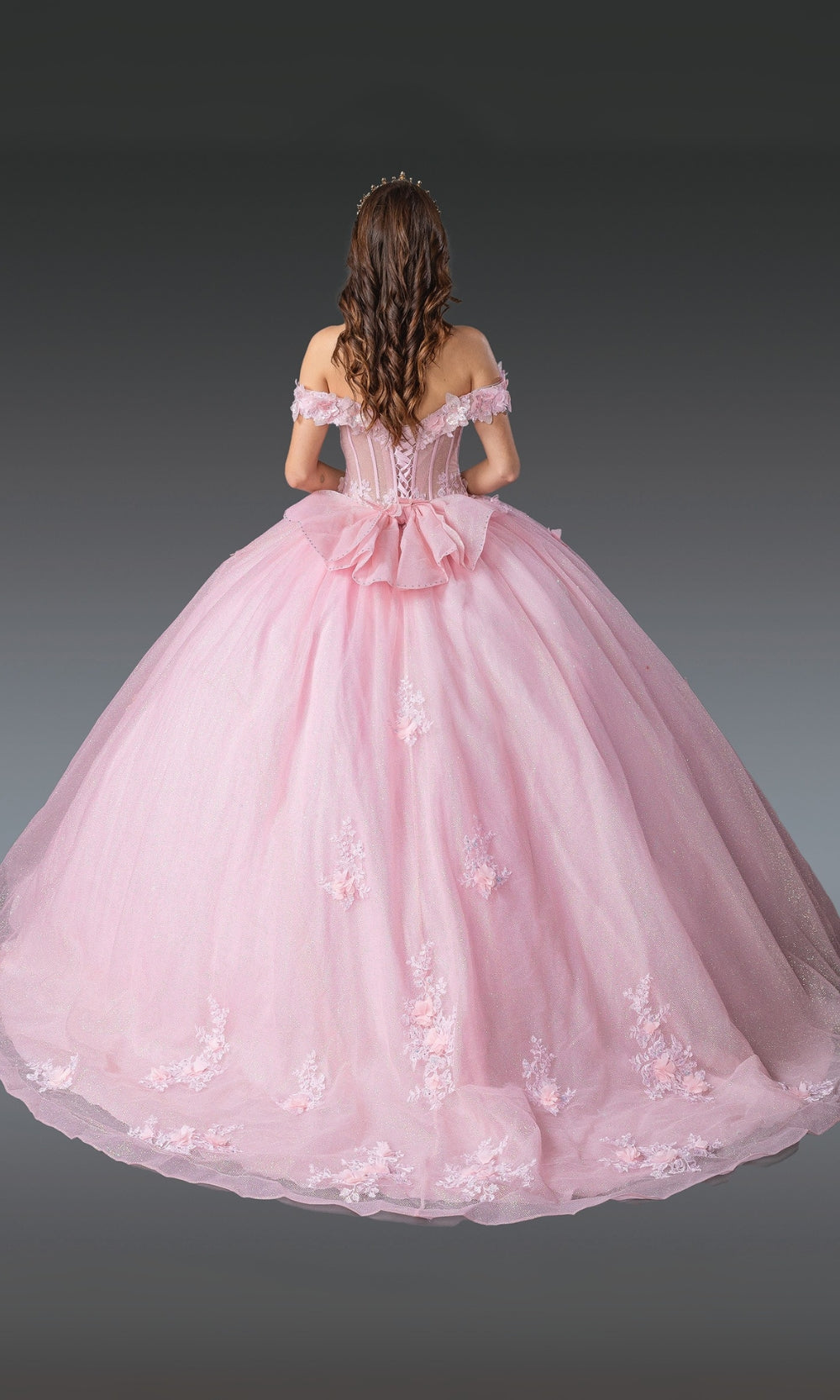 Pink ball gown with floral details on a plain background