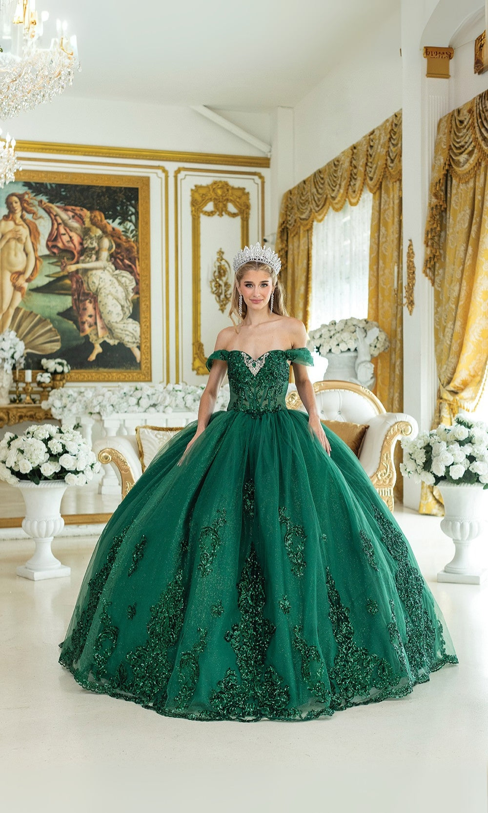 Woman in a green ball gown standing in an elegant room with decorative mirrors and flowers.