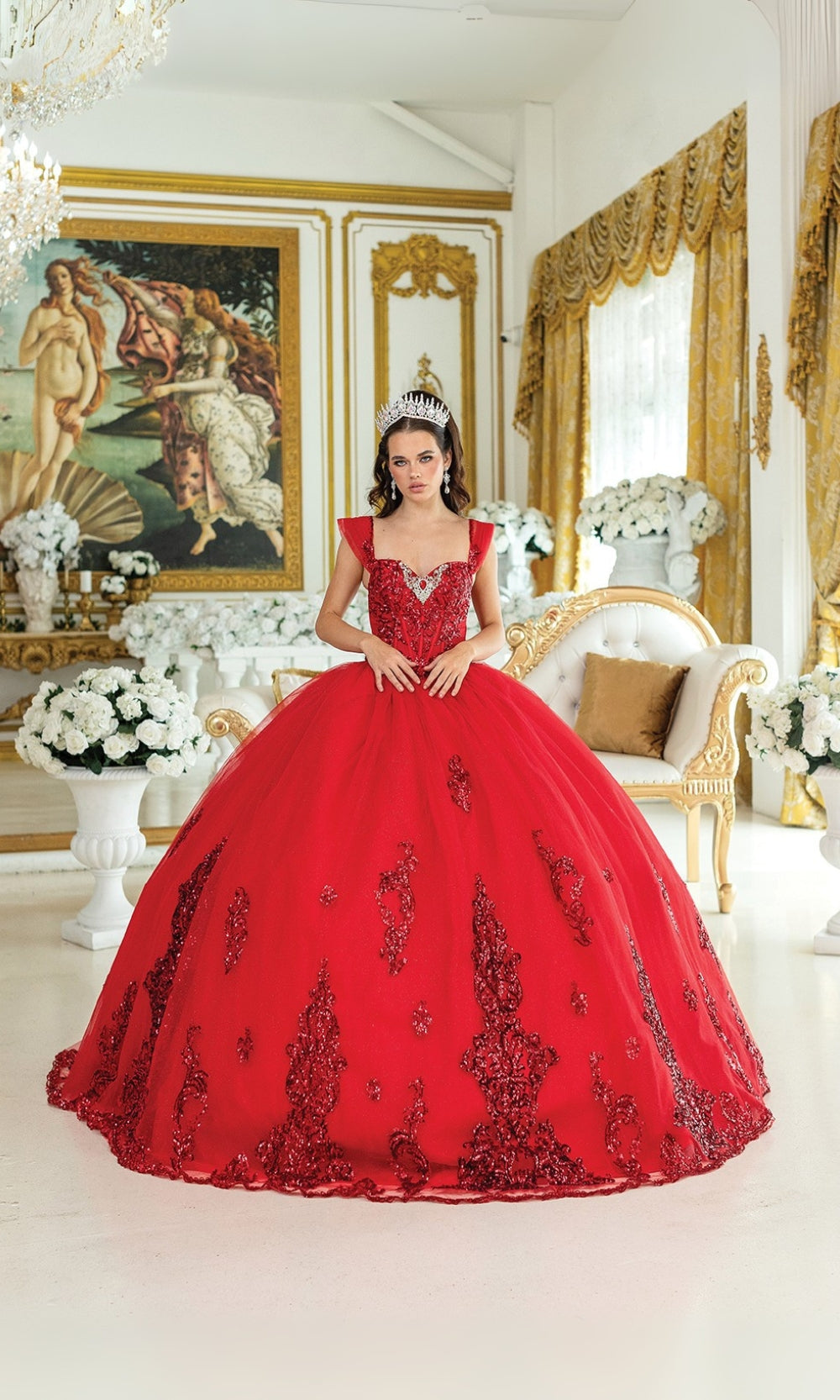 Woman in a red ball gown standing in an elegant room with gold accents and classical paintings.