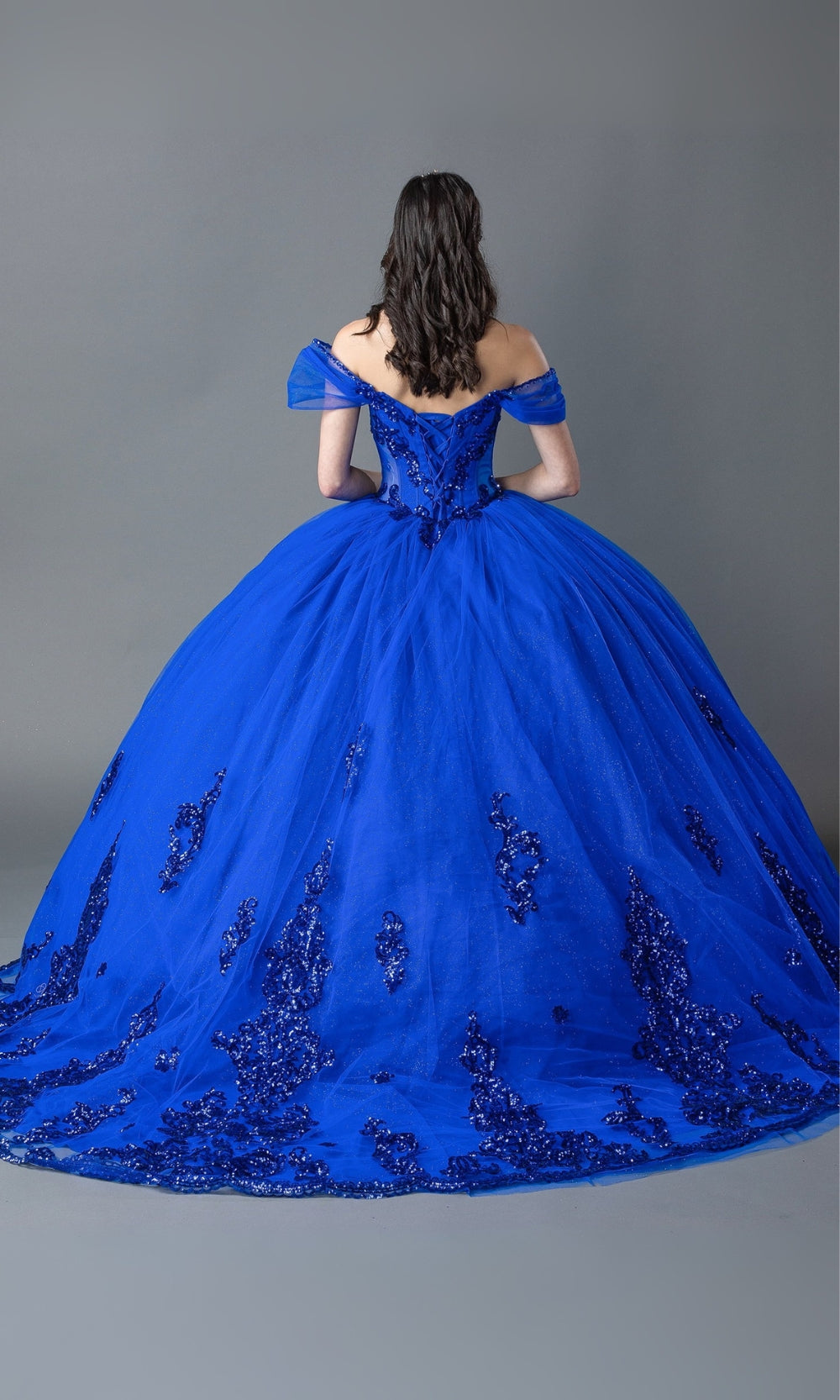 Blue ball gown with intricate detailing on a plain background
