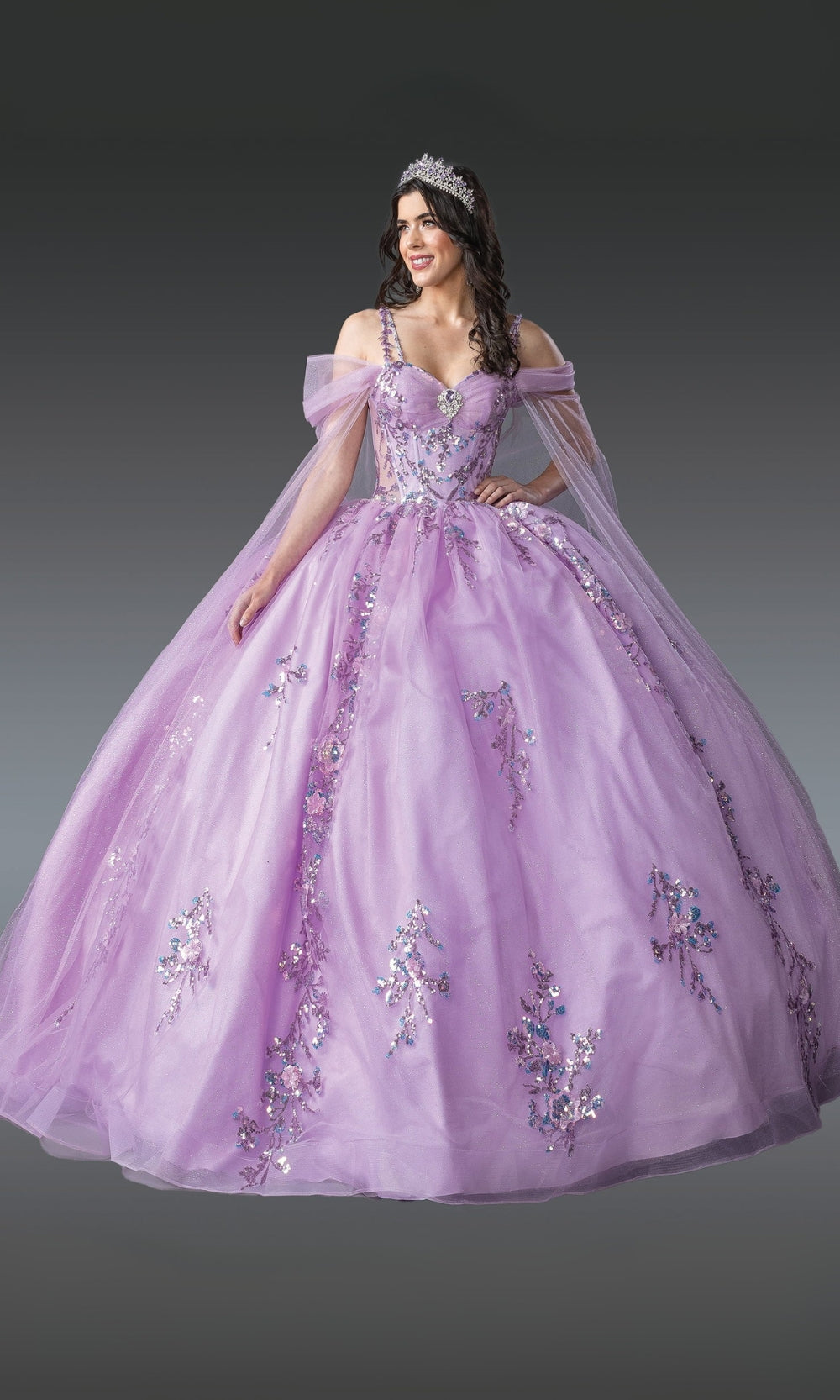 Woman wearing a purple ball gown with floral embellishments on a gray background