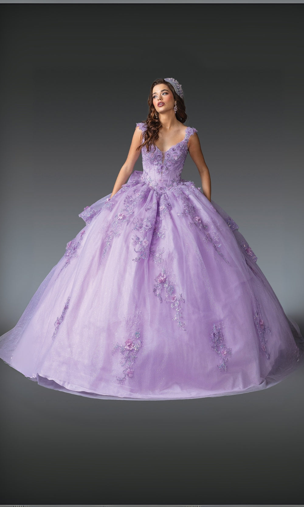 Woman wearing a purple ball gown with floral details on a gray background