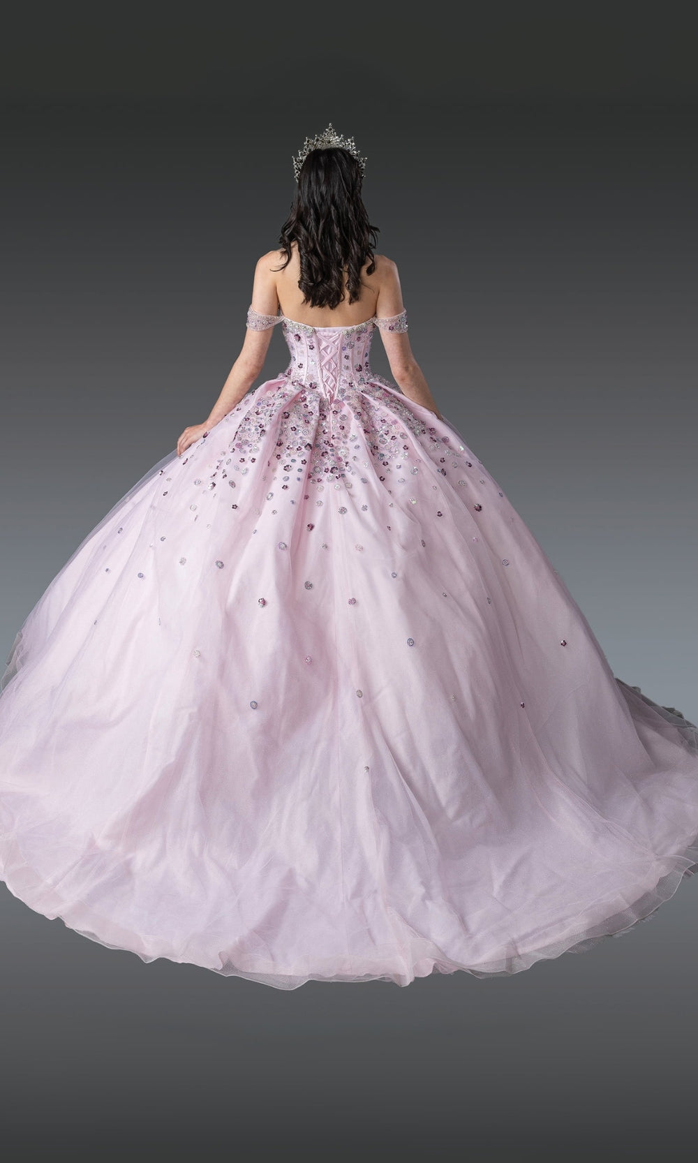 Pink ball gown with intricate details on a dark background