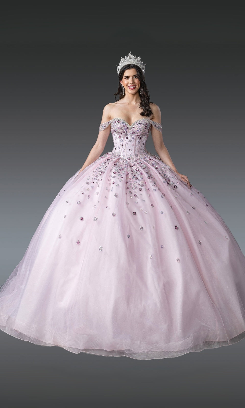 Woman in a pink formal gown with a tiara on a gray background
