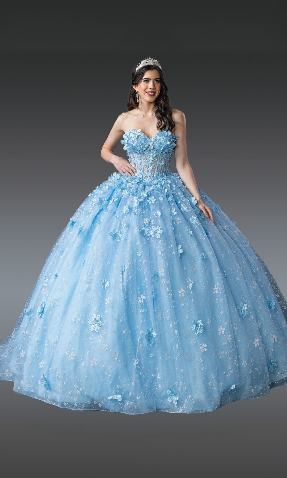 Woman wearing a blue floral ball gown against a gray background