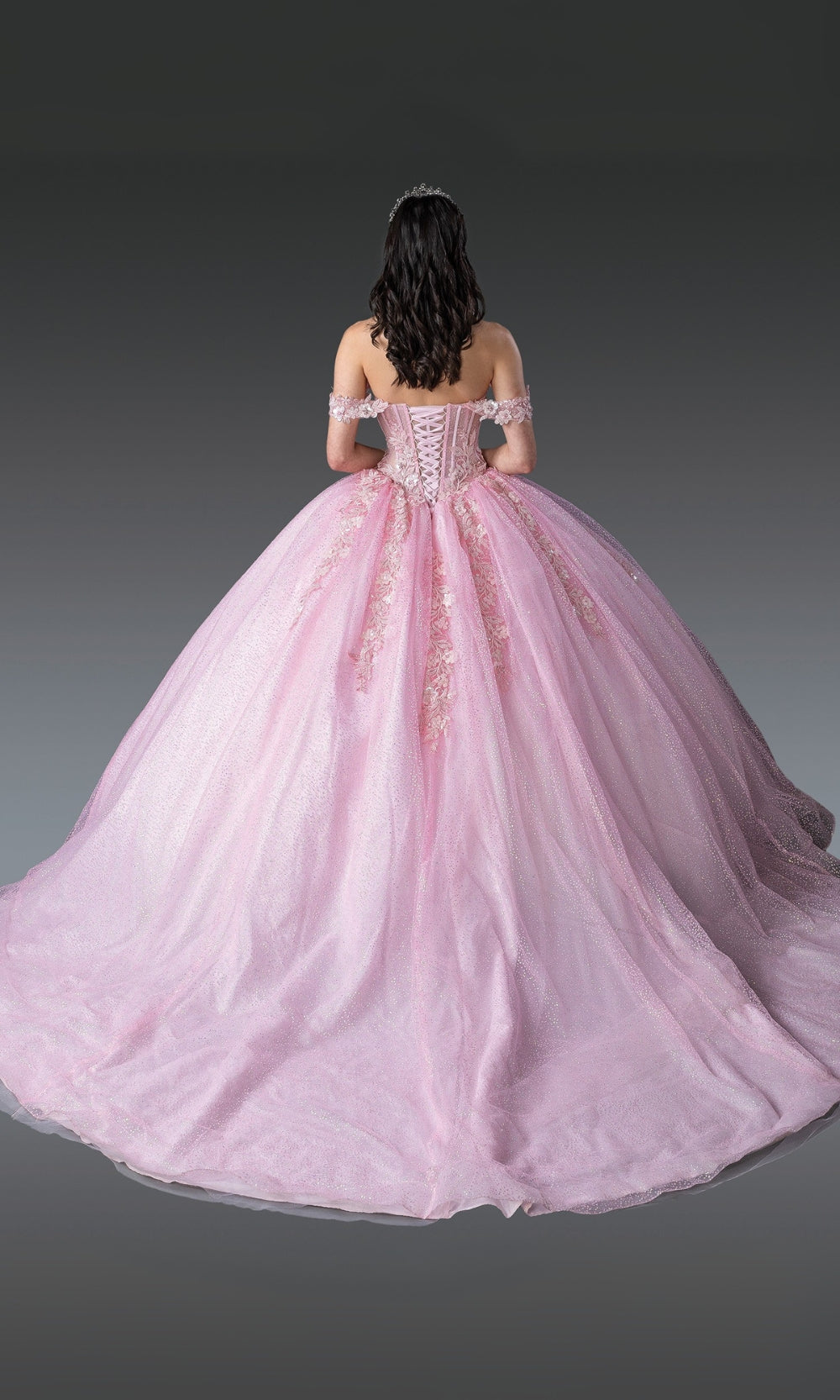 Pink ball gown with intricate details on a dark background
