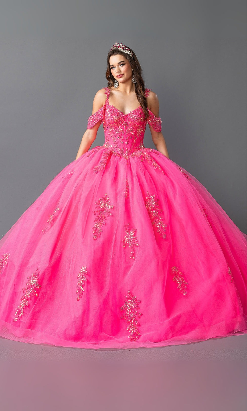 Pink quinceanera dress with floral embroidery on a gray background