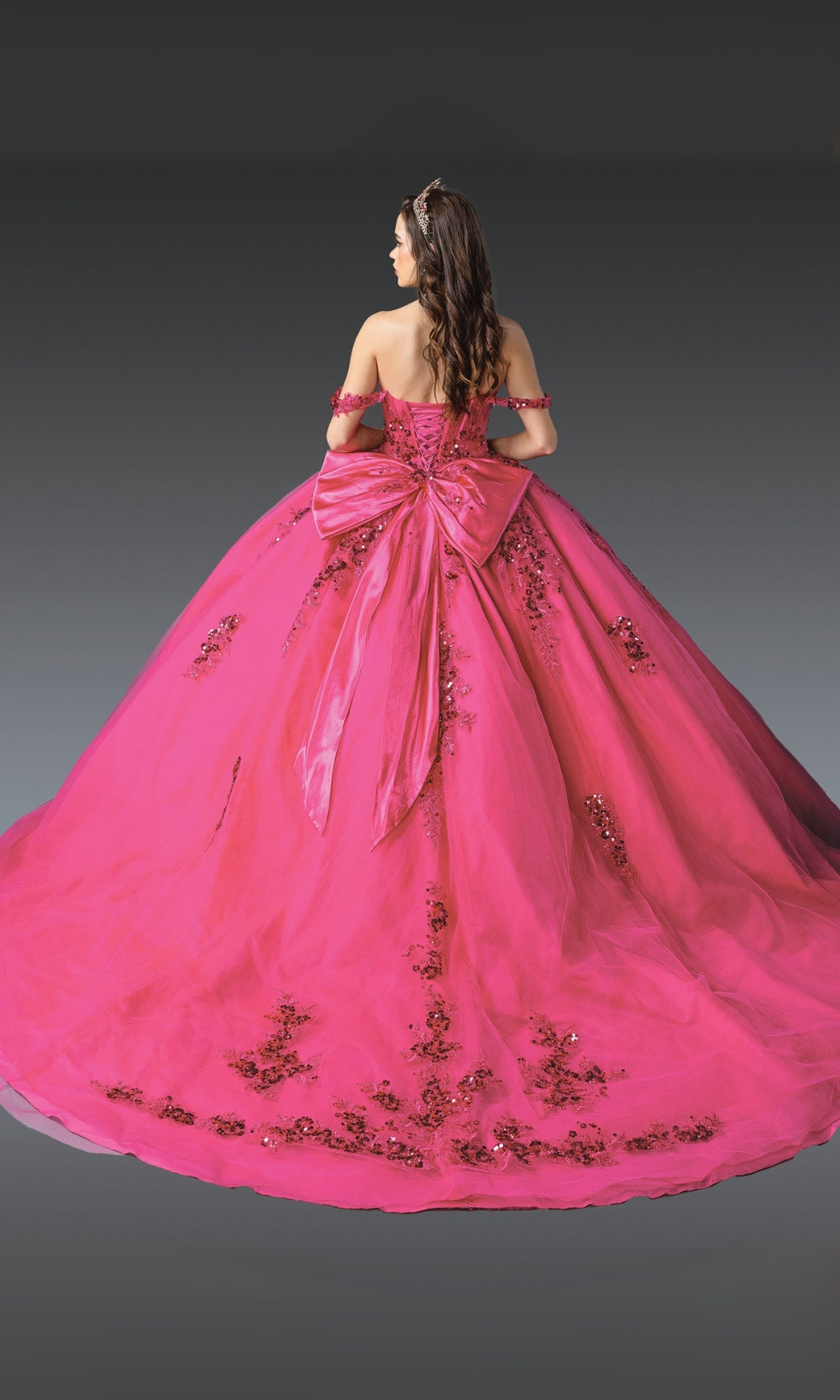 Pink ball gown with intricate detailing on a plain background
