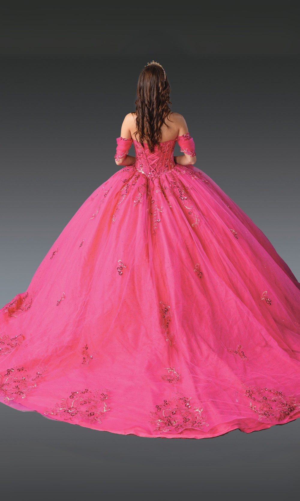 Pink ball gown with intricate details on a plain background