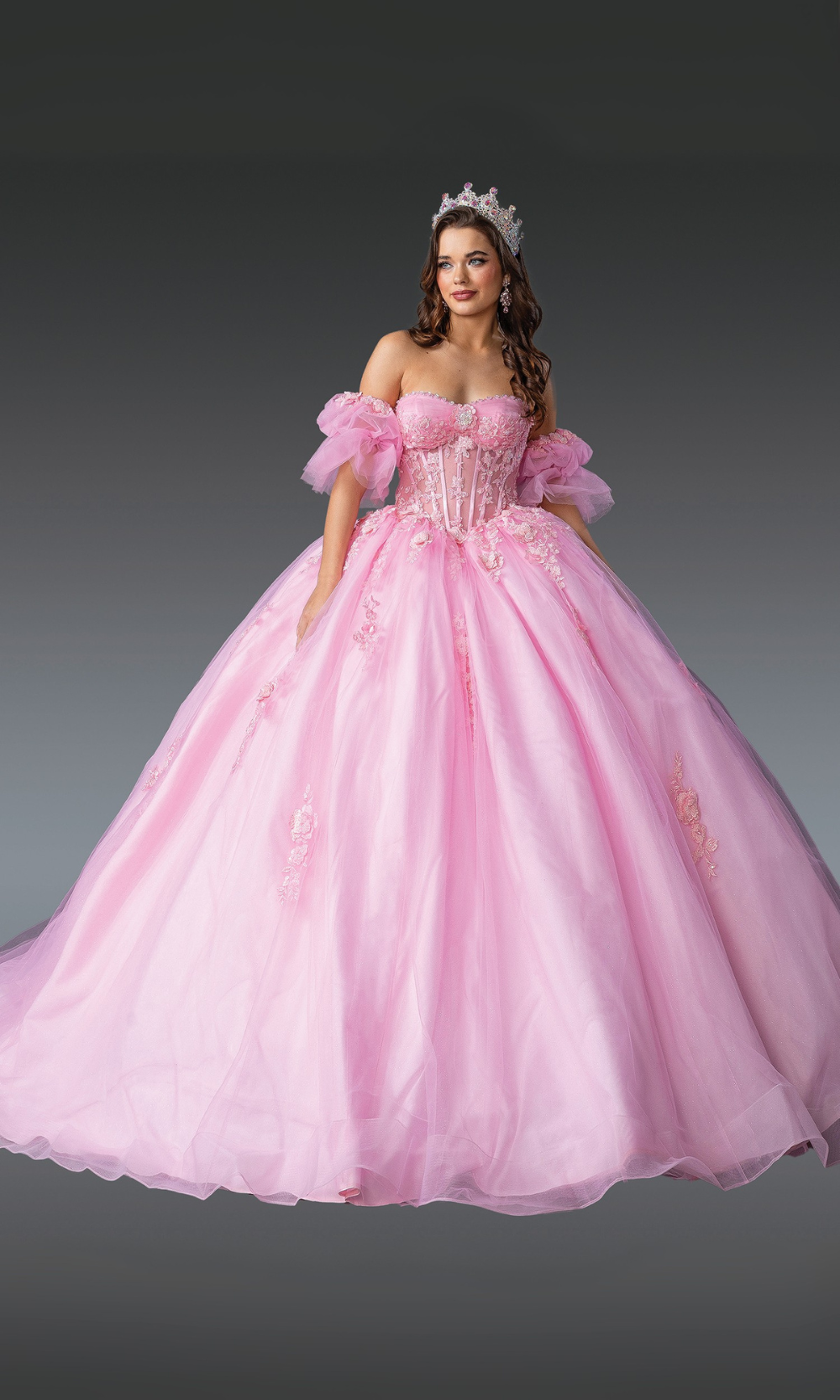 Woman in a pink quinceañera dress with a tiara on a gray background