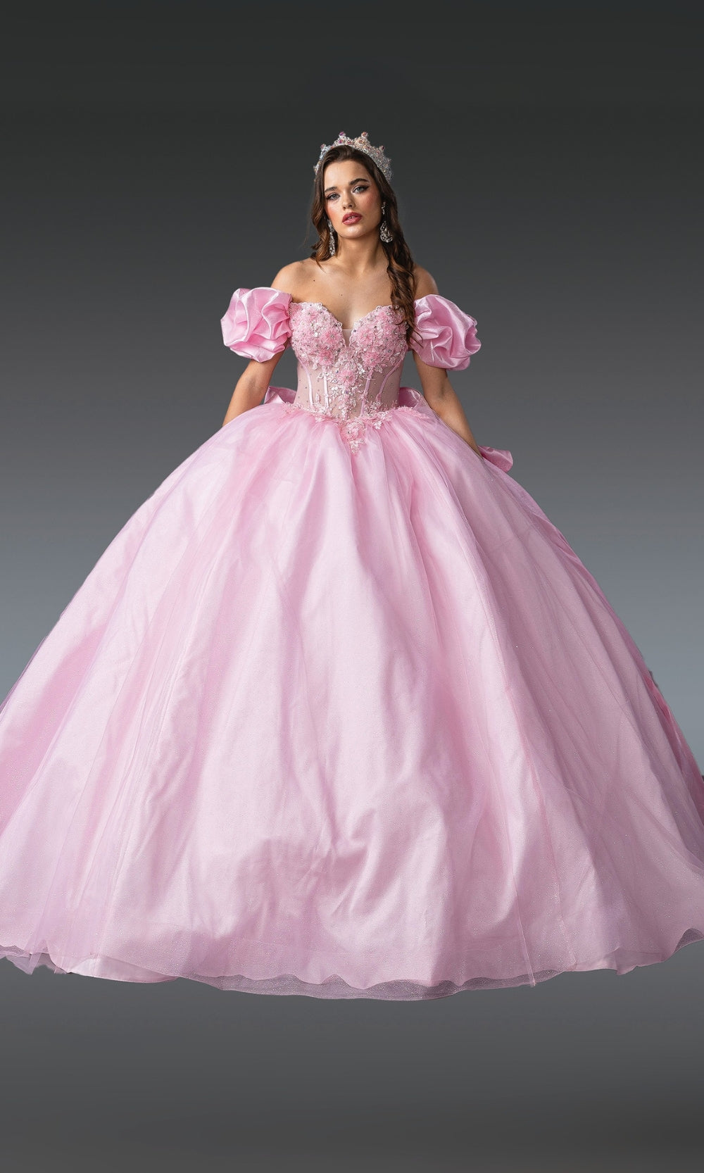 Woman wearing a pink ball gown with a gray background