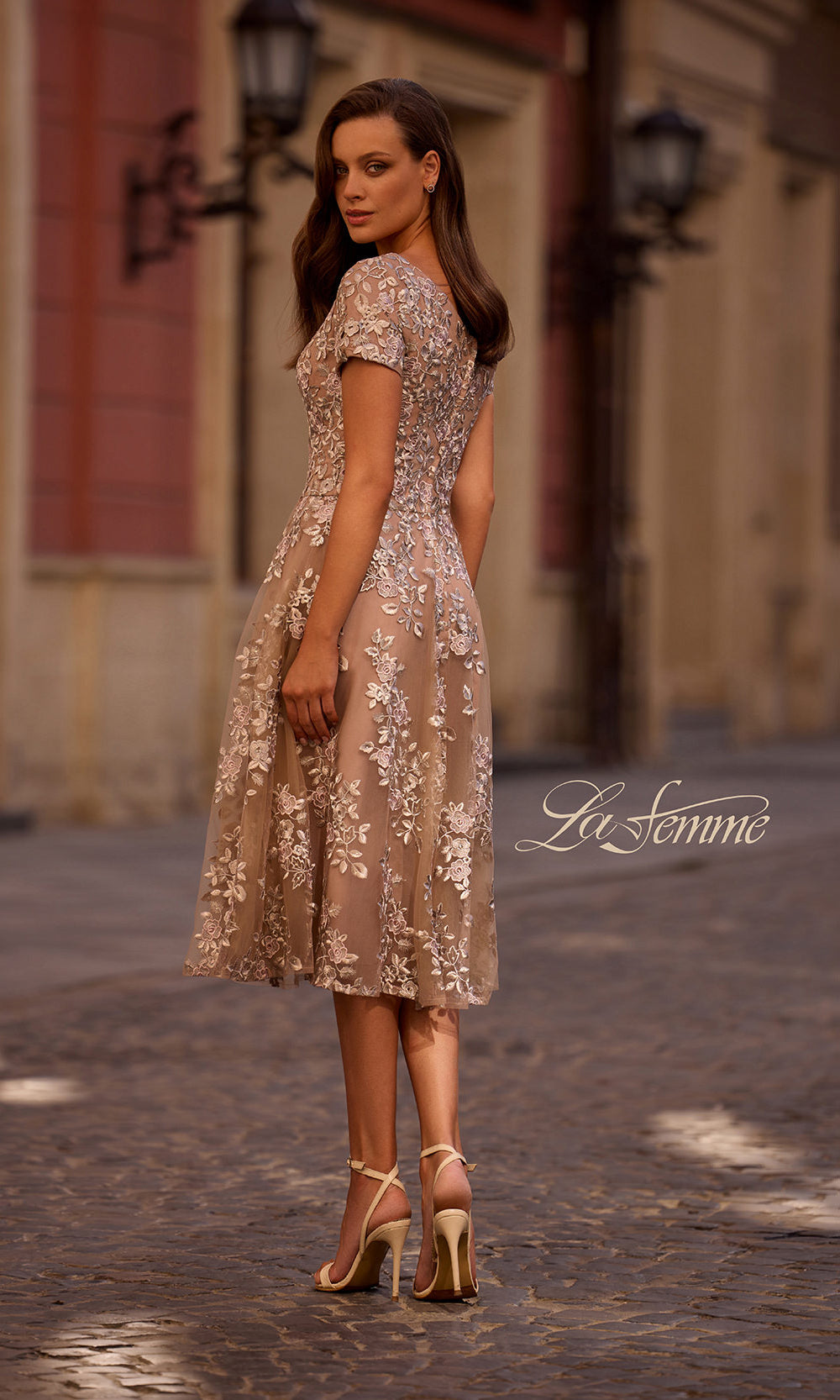 Woman in a floral dress standing on a street with 'Le Femme' branding.