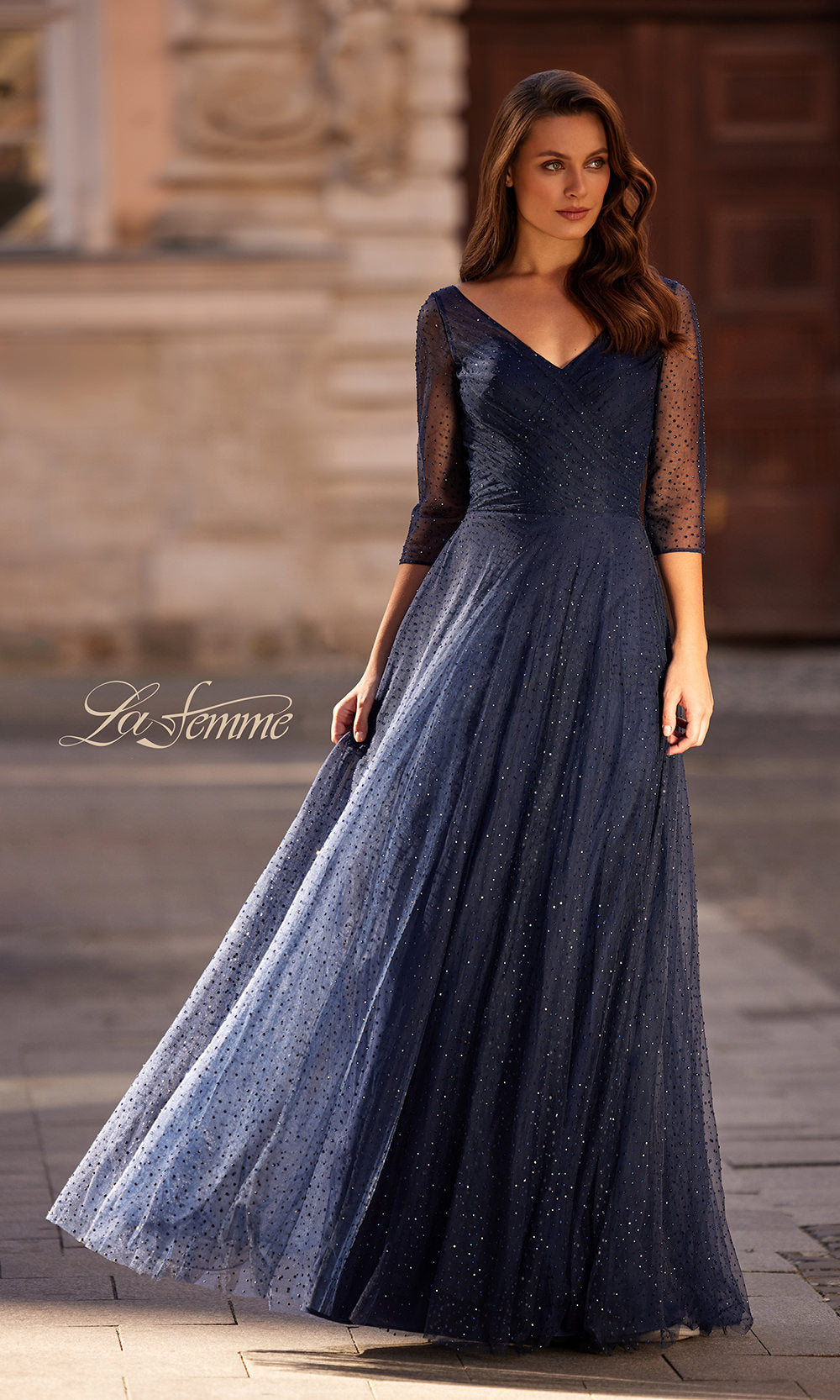 Woman wearing a long navy blue dress with a blurred background