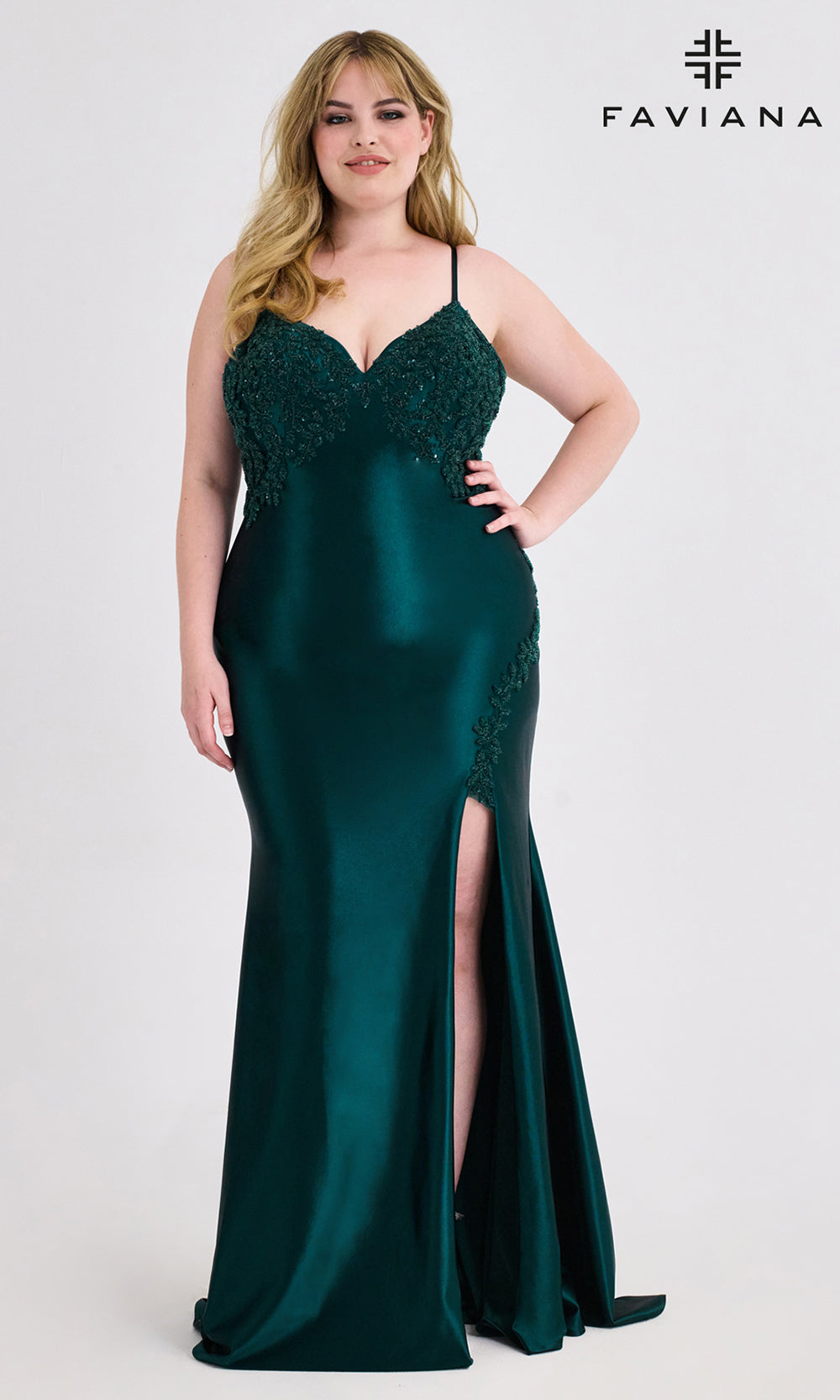 Woman wearing a green evening gown with lace detailing, standing against a white background with 'Faviana' branding.