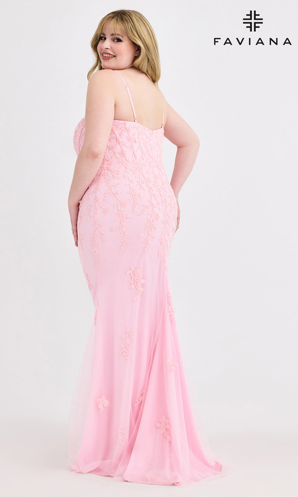 Woman wearing a pink dress with Faviana branding on a white background