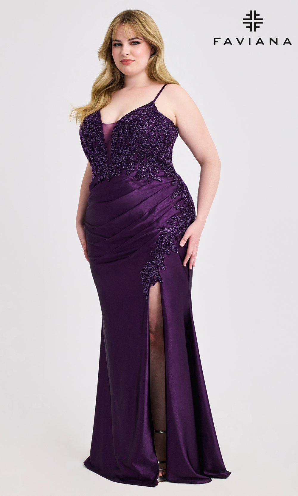 Woman wearing a purple evening gown with a slit on a white background, branded 'Faviana'.