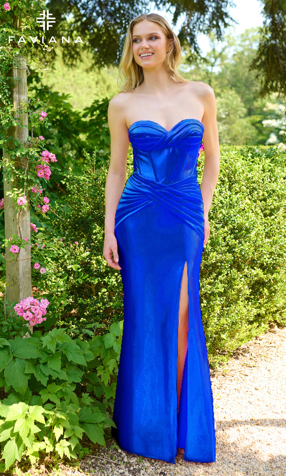 Woman wearing a blue strapless gown with a slit in a garden setting