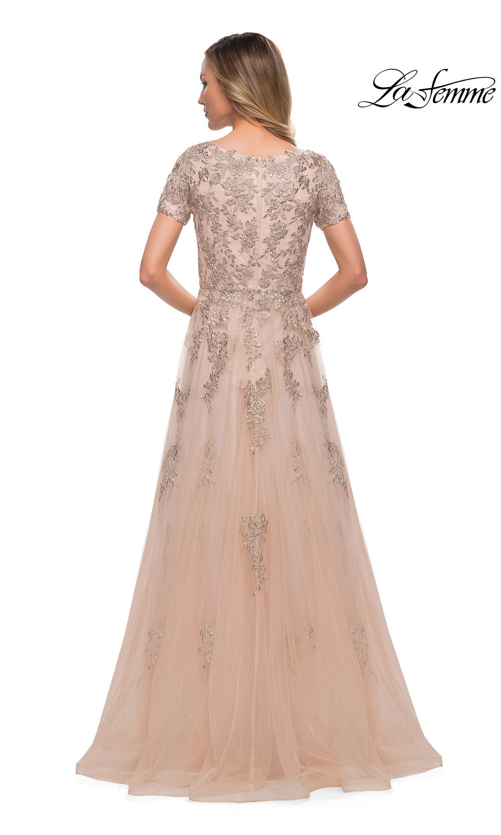 Woman wearing a long, elegant dress with lace details on a white background