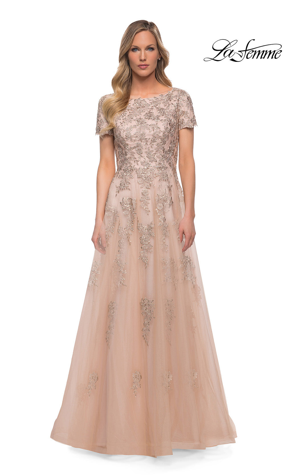 Woman wearing a beige evening gown with lace details on a white background