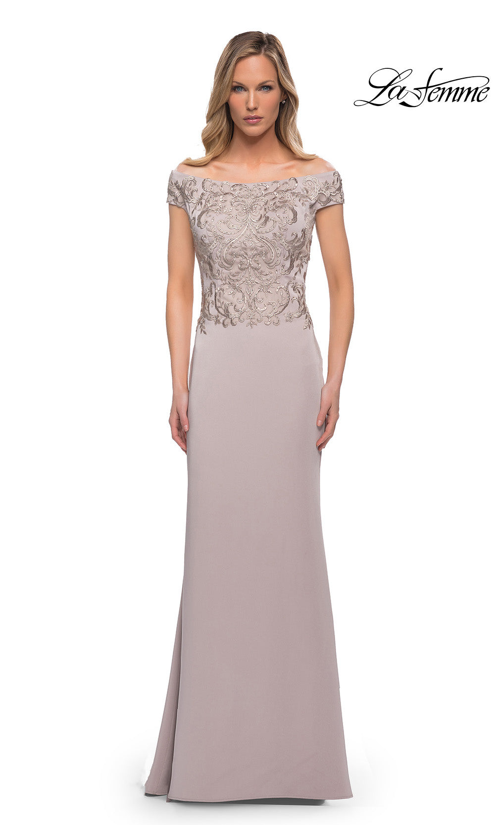 Woman wearing a long, elegant dress with lace top and solid skirt on a white background