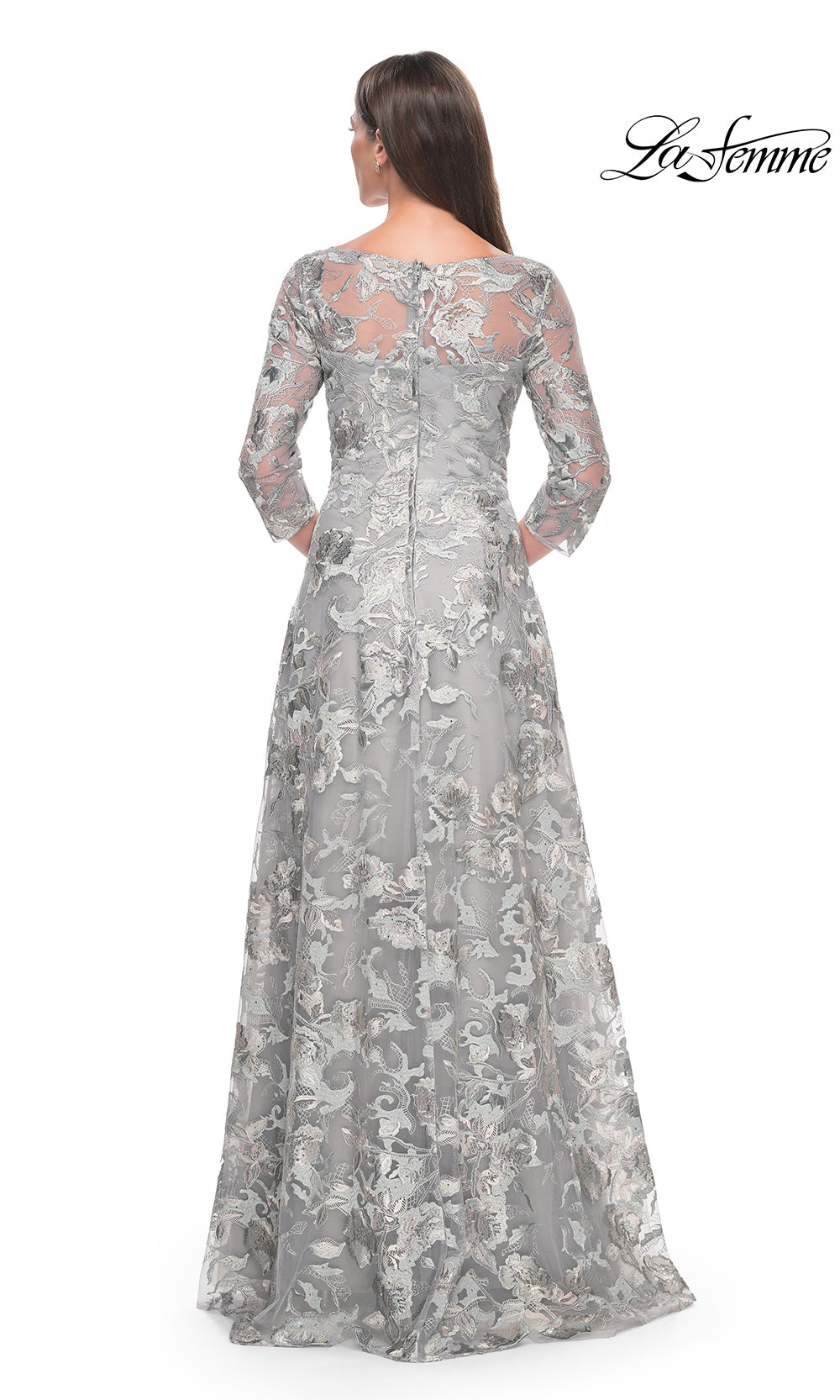 Woman wearing a gray lace evening gown on a white background