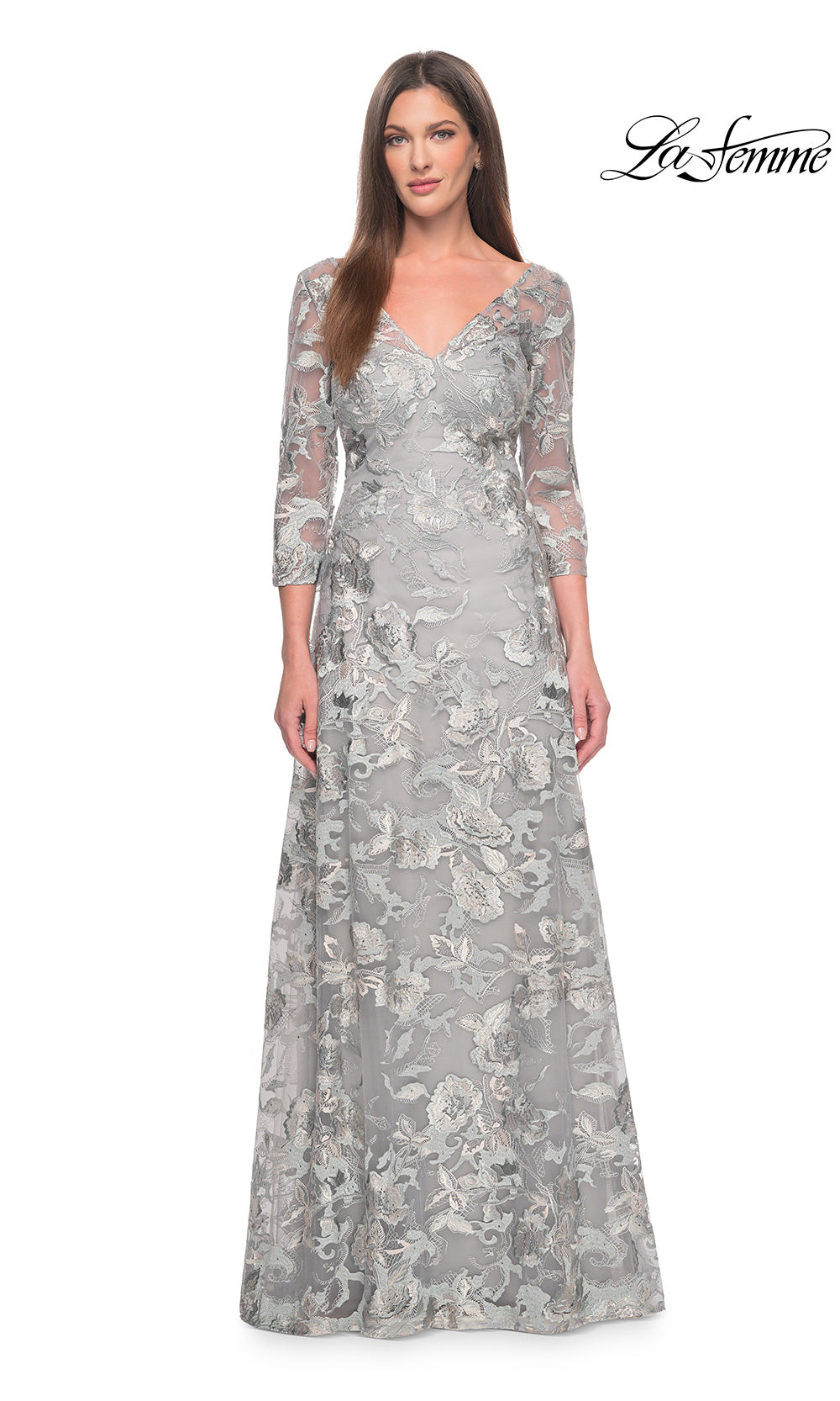 Woman wearing a silver lace evening gown on a white background