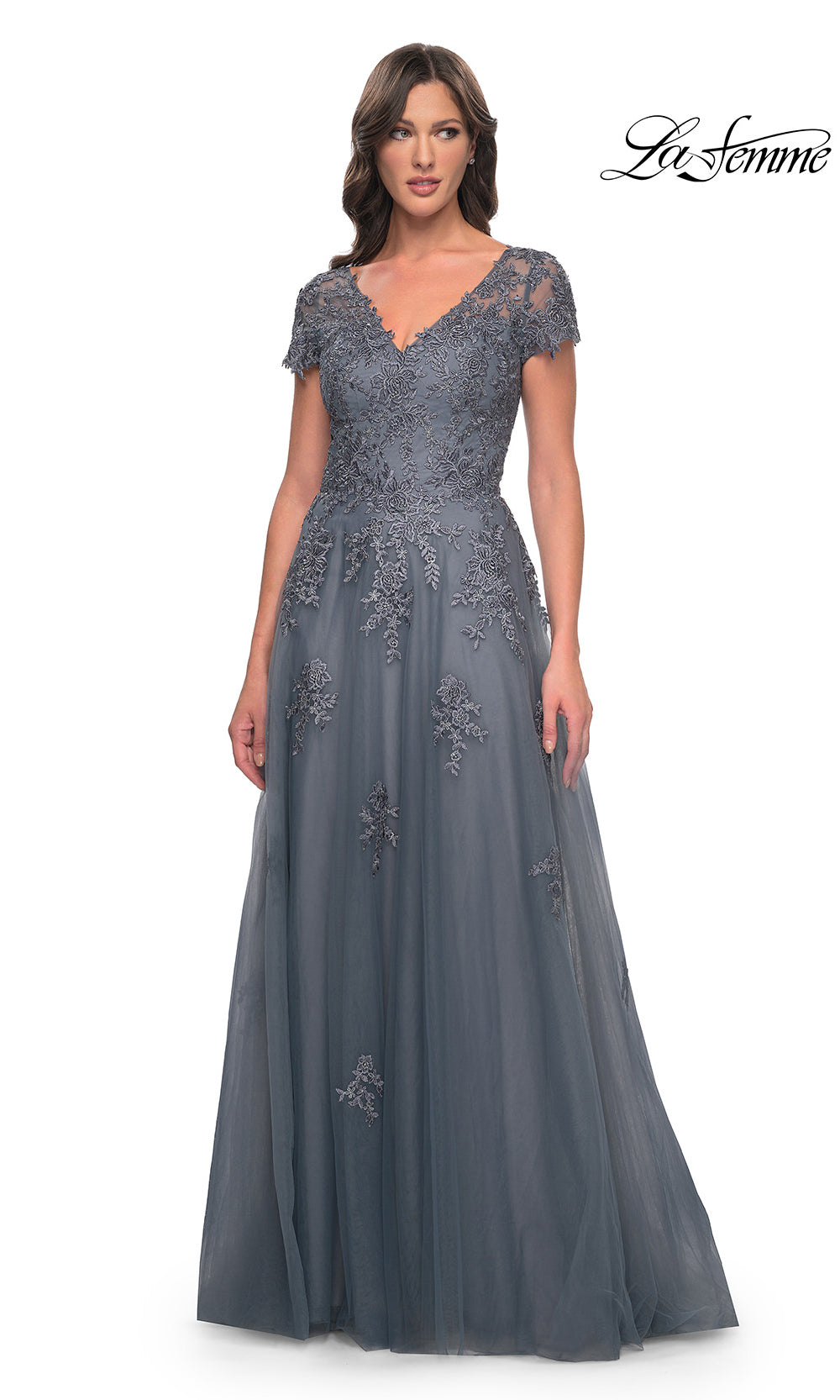 Woman wearing a gray evening gown with lace details on a white background