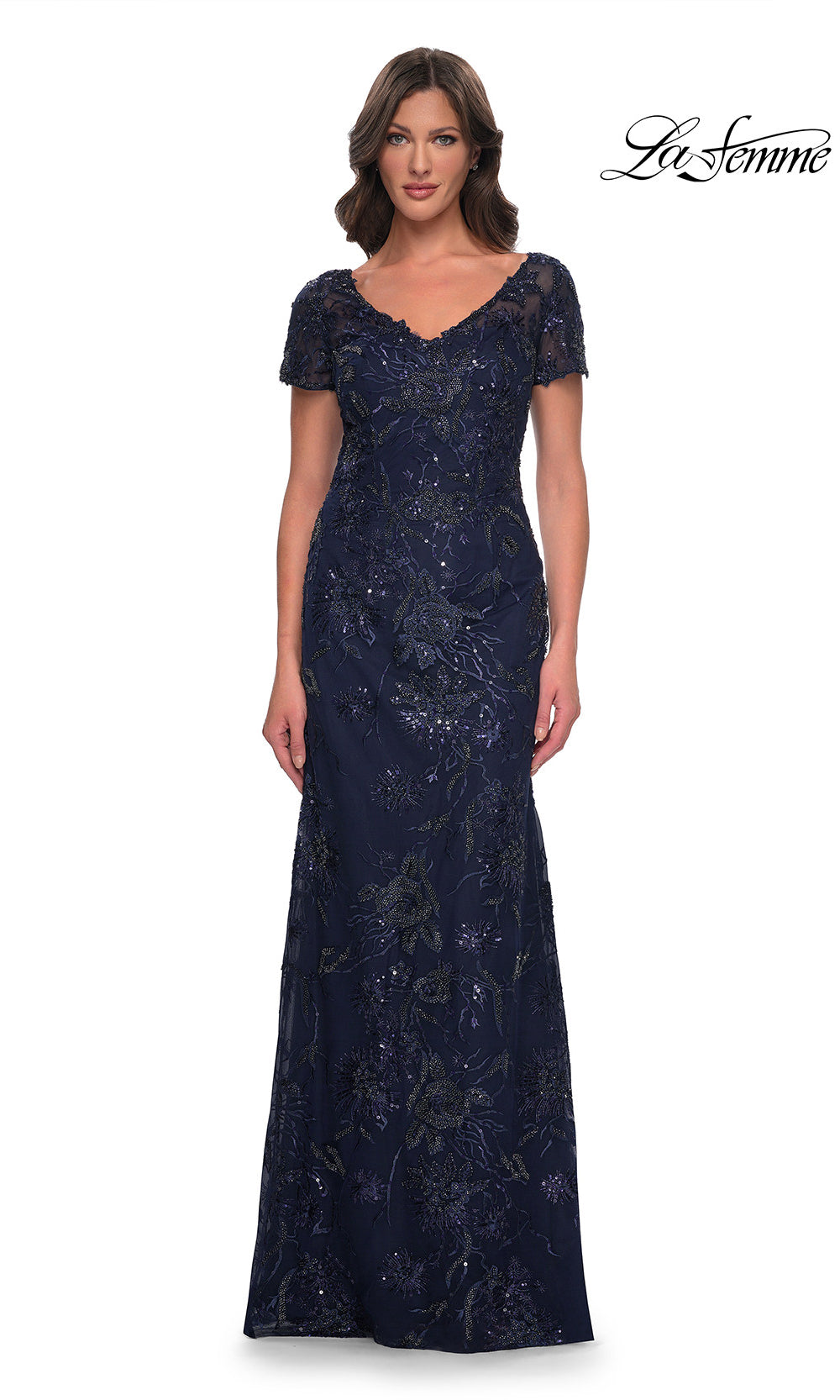 Woman wearing a navy blue lace evening gown on a white background