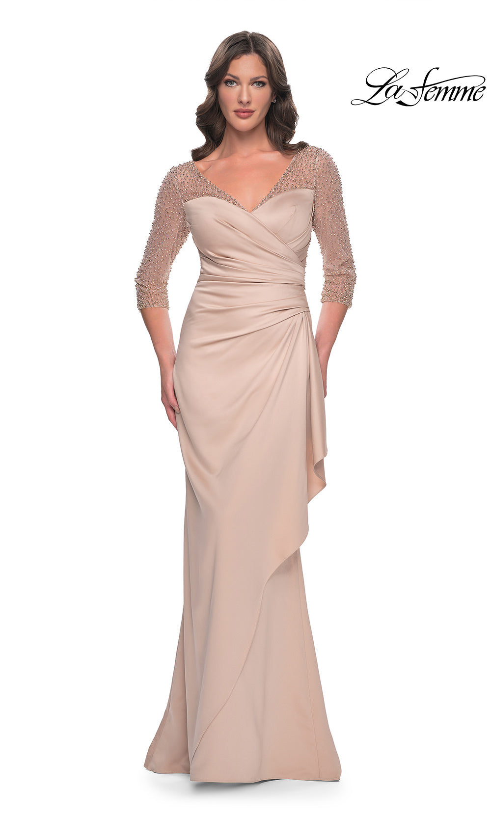 Woman wearing a beige evening gown with lace sleeves on a white background, branded 'La Femme'.