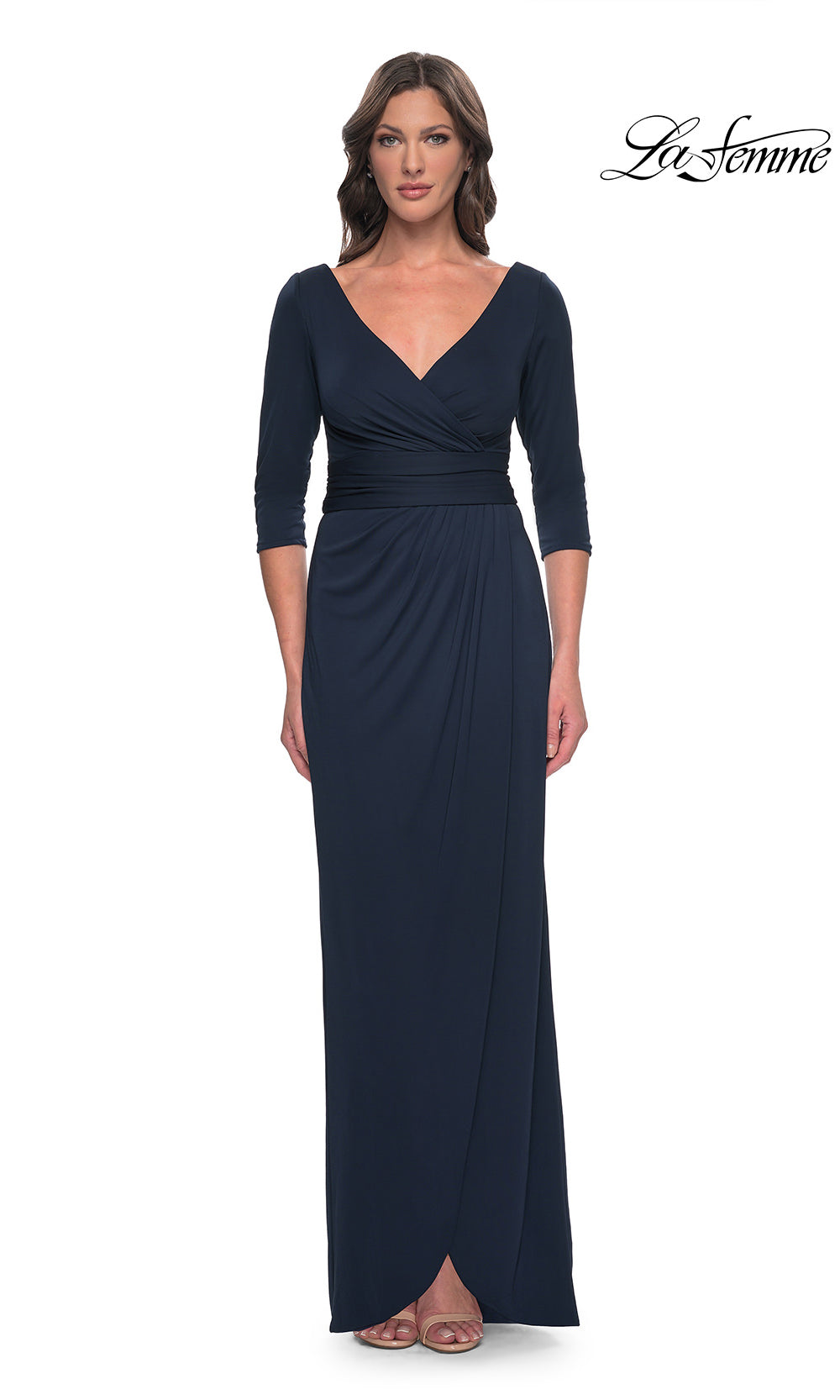 Woman wearing a navy blue evening gown with a V-neckline and three-quarter sleeves on a white background.