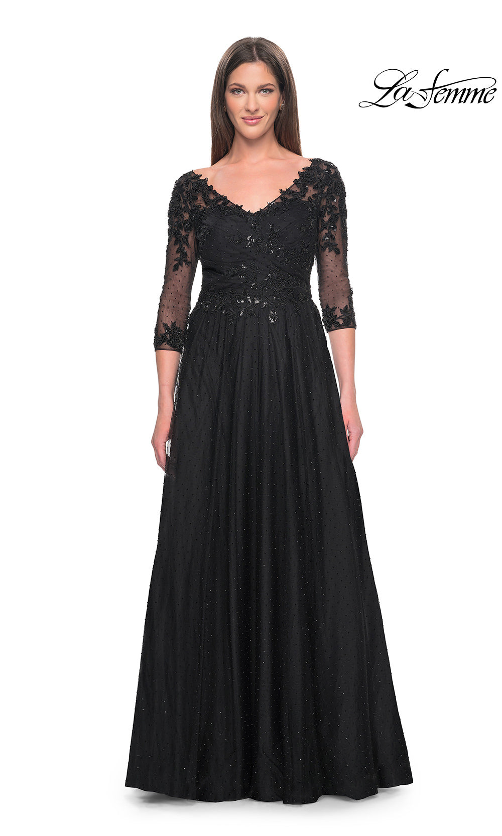 Woman wearing a black evening gown with lace sleeves on a white background