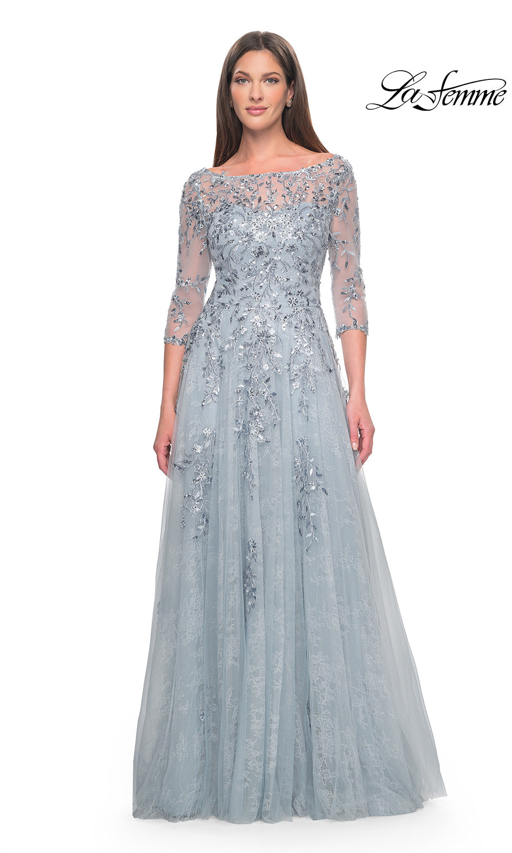 Woman wearing a silver evening gown with lace details on a white background