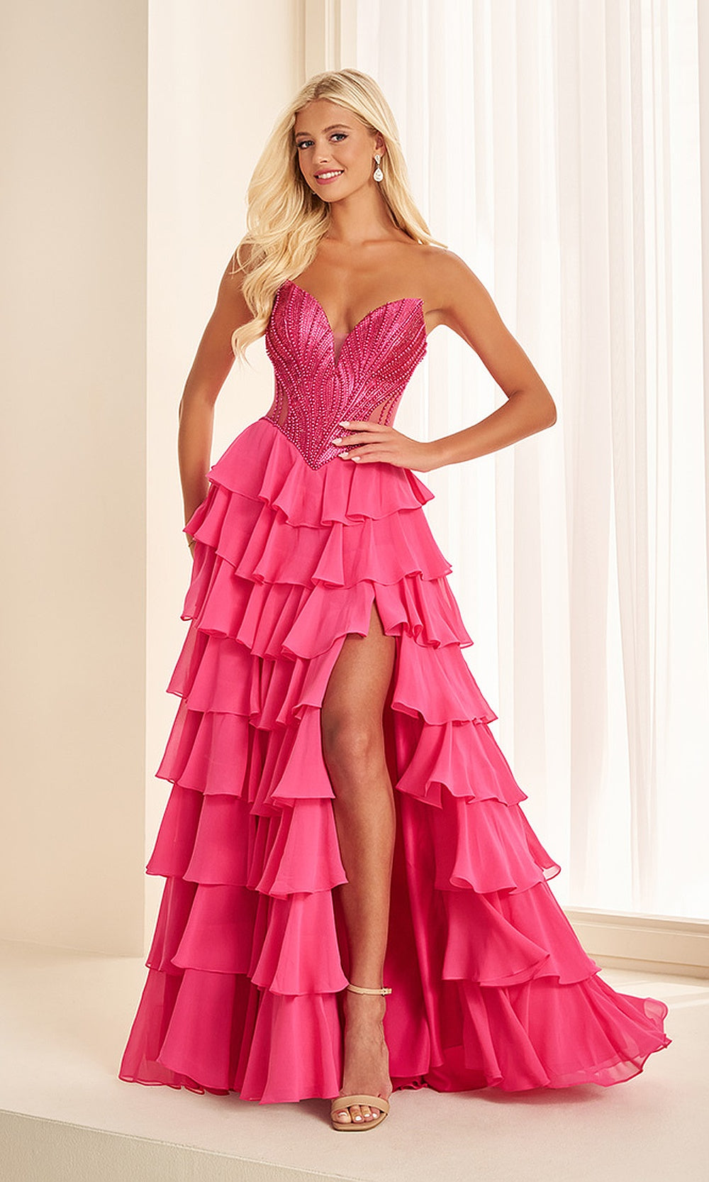 Ellie Wilde EW38019 Hot Pink prom dress front view with beaded chiffon, strapless corset bodice, high slit, and ruffle skirt gala gown.