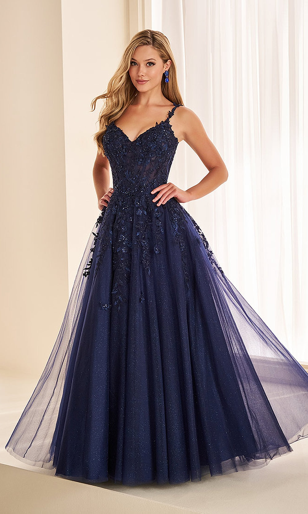 Ellie Wilde EW38060 Navy Blue prom dress front view with glitter tulle, floral appliqué sheer corset bodice, A-line ballgown, formal prom gown