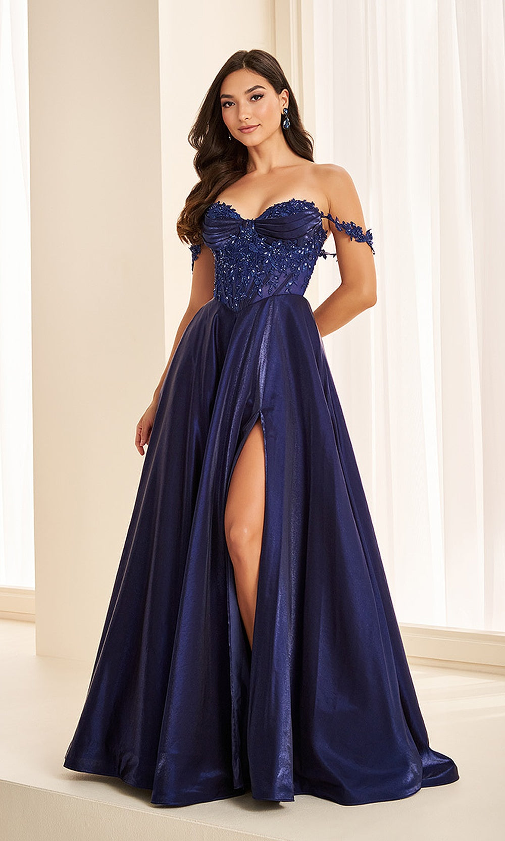 Ellie Wilde EW38218 Sapphire off-shoulder beaded lace prom dress front view with satin, floral appliques, a-line ballgown silhouette, black tie event dress.