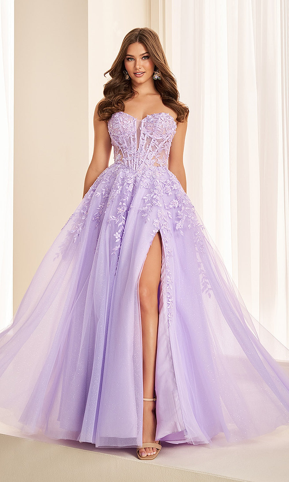 Ellie Wilde EW38221 Lilac prom dress front view with lace and glitter organza, boned corset bodice and floral appliques, sweetheart a-line ballgown silhouette, black tie event dress.