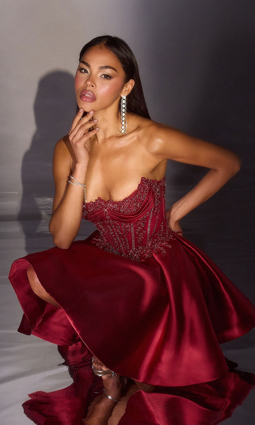 Ladivine CC502 burgundy homecoming dress editorial view with illusion mesh beaded corset bodice, floral appliqués at waistline, fit-and-flare satin skirt, short semi-formal dance dress