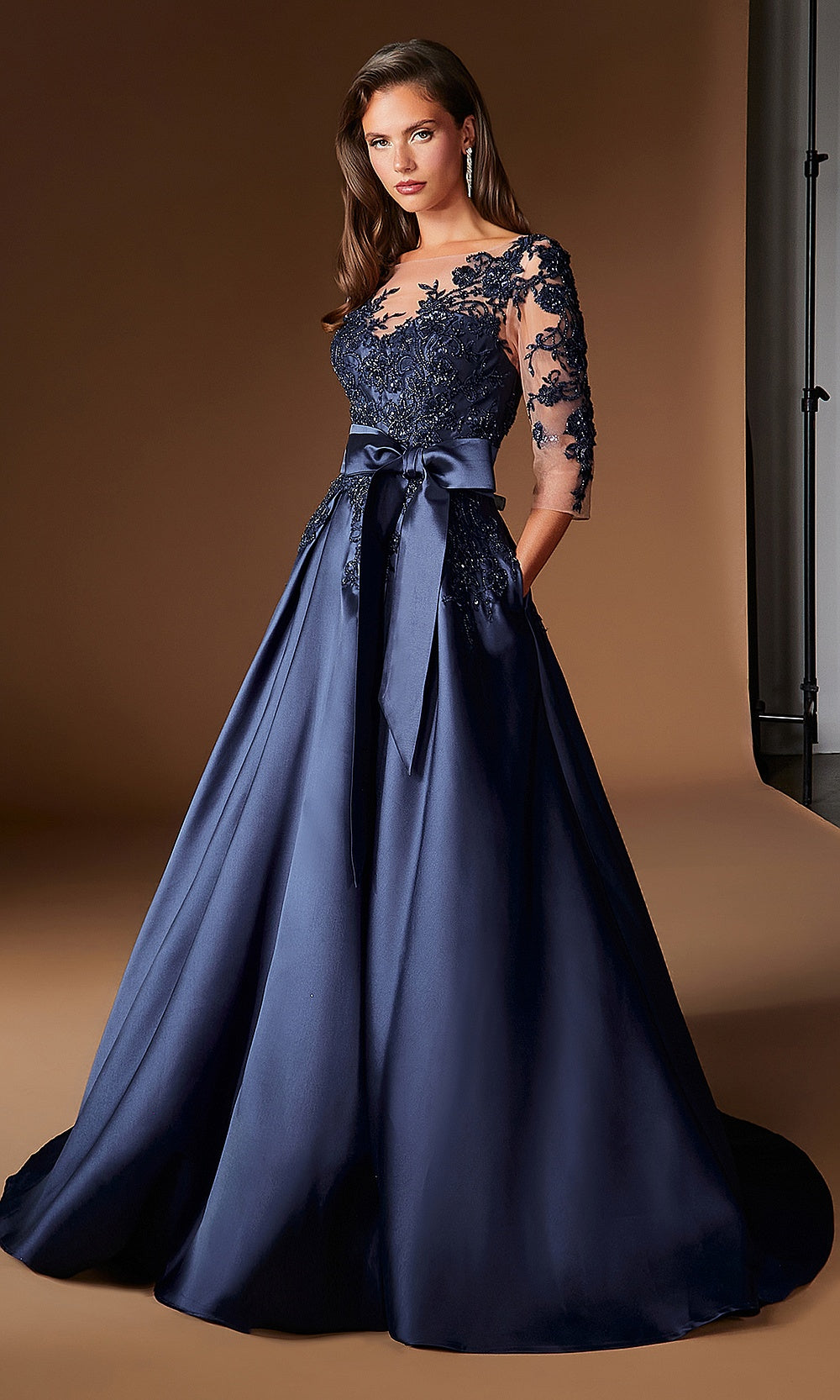 Ladivine CDS569 navy long ballgown with sheer mesh sleeves, embroidered lace detail, satin bow waist, full silhouette side view, formal wedding celebration dress, a mother-of-the-bride favorite
