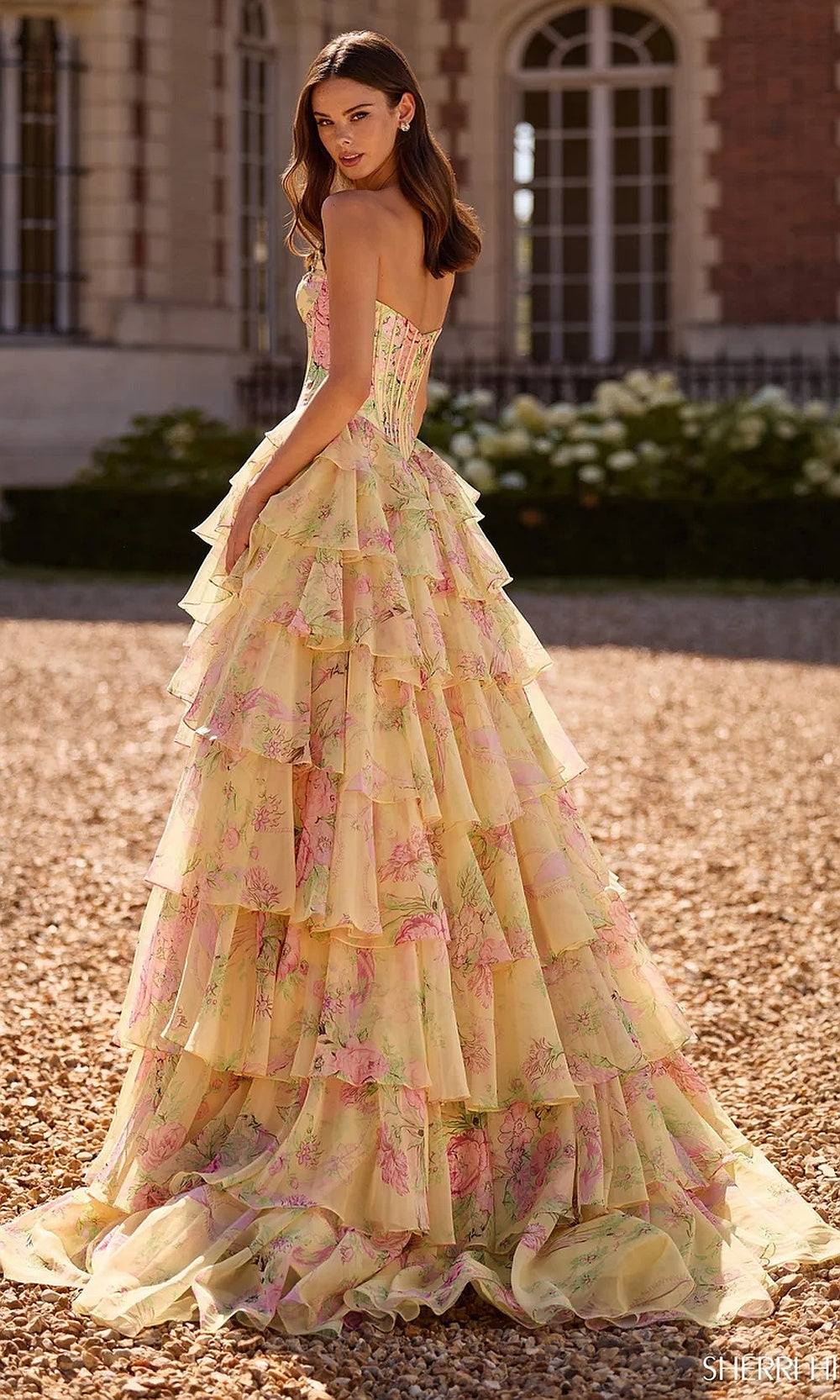 Sherri Hill 57727 Light Yellow Print prom dress back view with open corset back, floral-print chiffon tiered ruffle skirt, and sweep train, evening gown