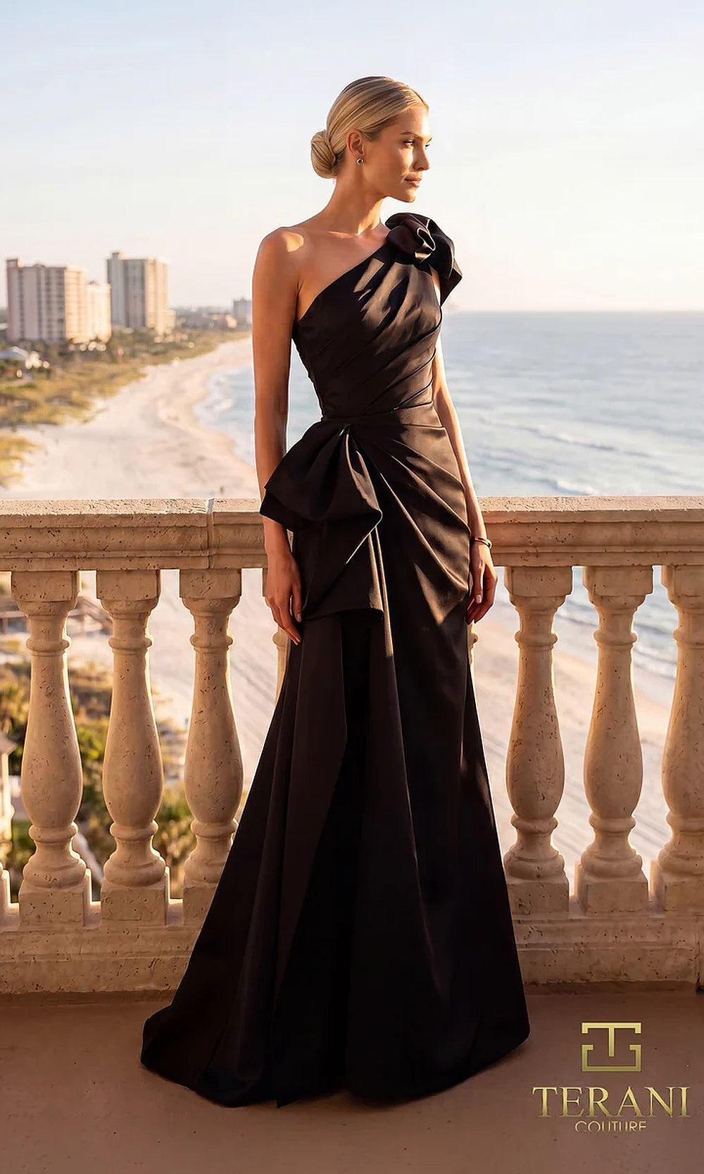 Terani Couture 262E7132 Black formal evening dress front view with one-shoulder ruffle bow neckline, ruched crepe column with sculpted side bow, black tie event dress