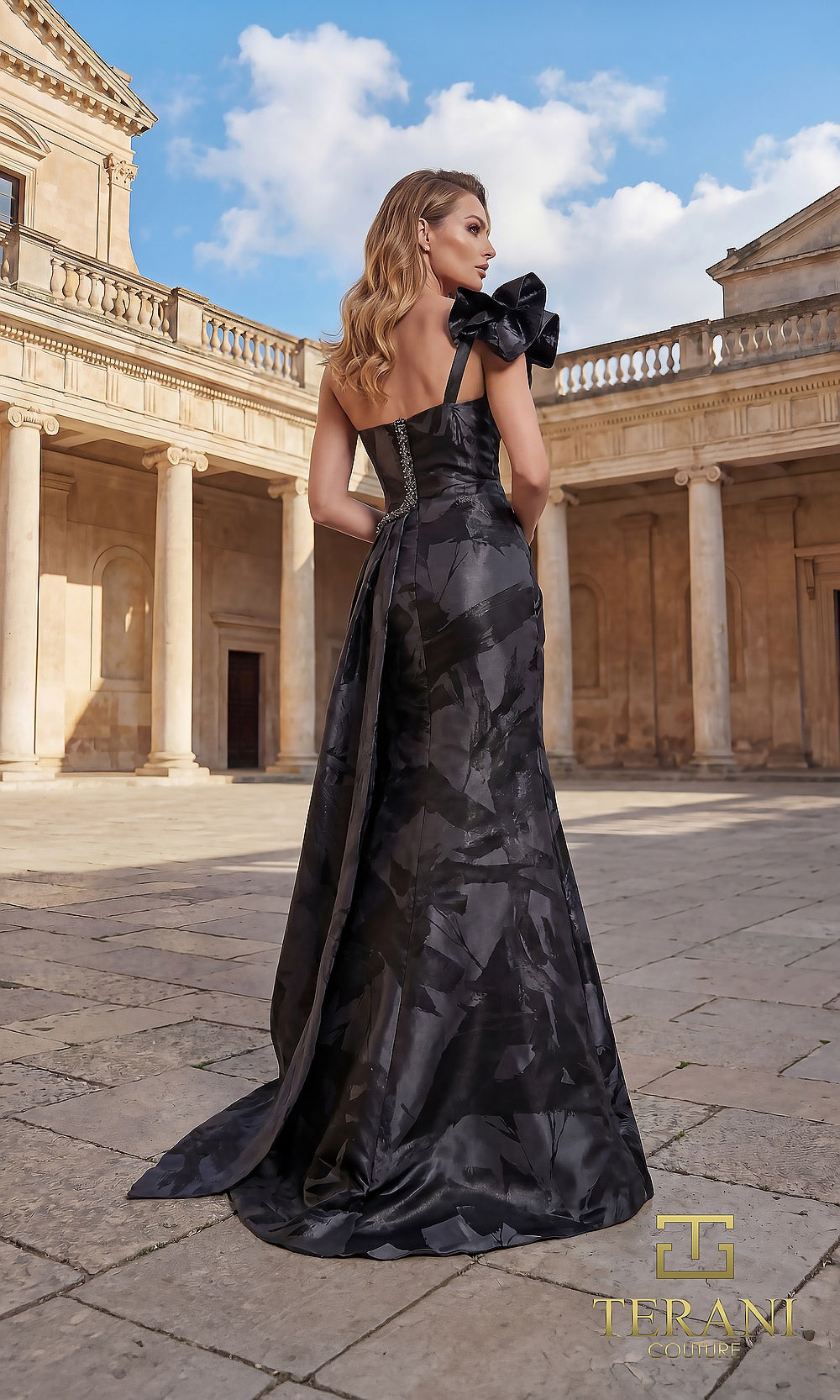 Terani Couture 262E7376 Black formal evening dress back view with one-shoulder ruffle bow, tonal jacquard A-line with sweep train, gala gown