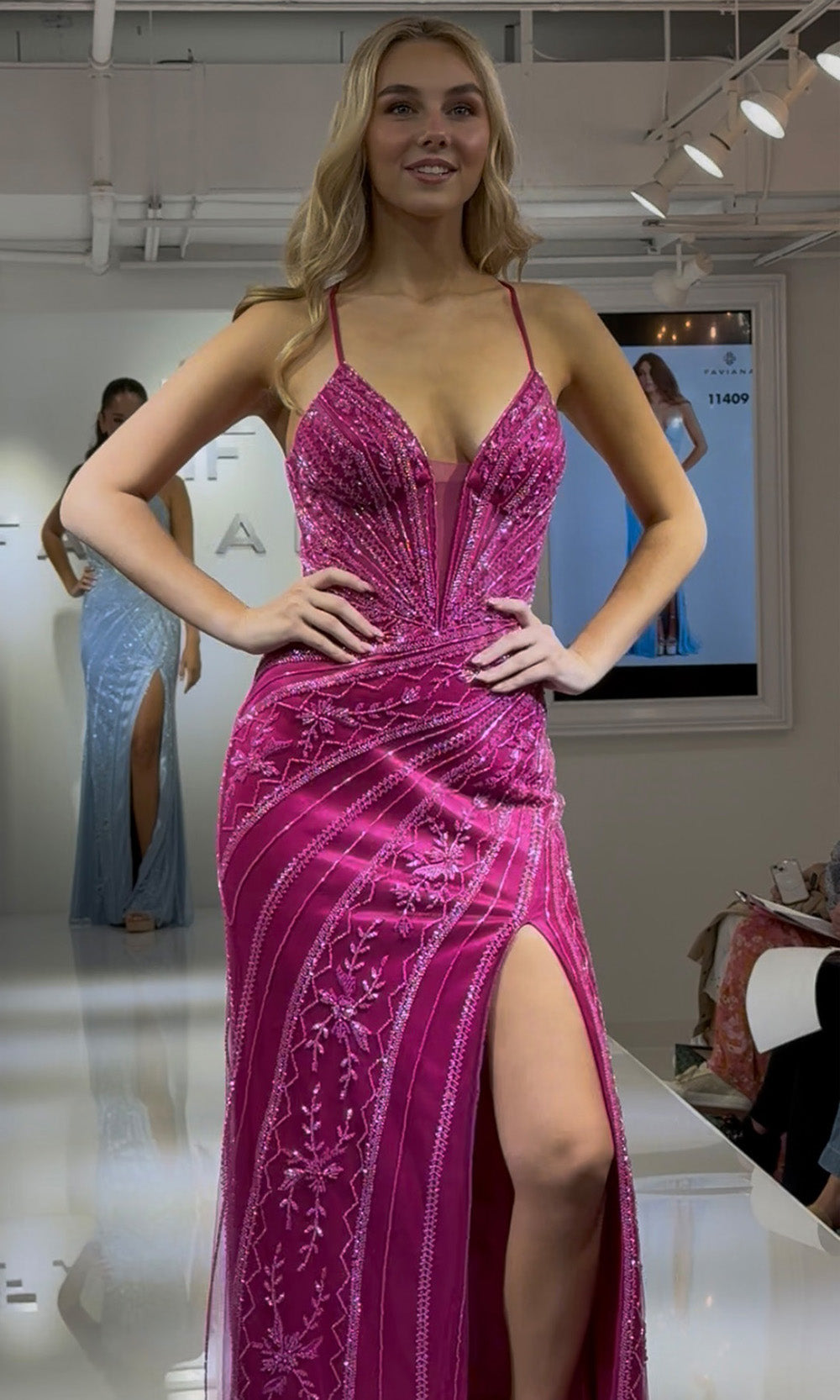 Woman wearing a pink evening gown in a store setting